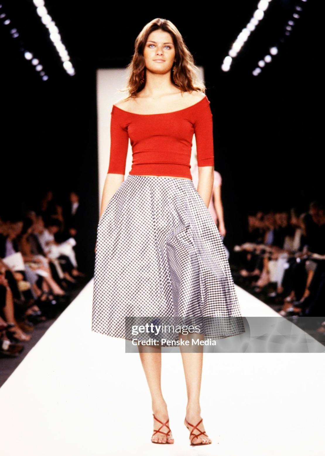 Esta falda midi Ralph Lauren, nueva con etiquetas, de la colección Primavera/Verano 2000, está confeccionada en tafetán de seda de guinga blanca y negra. Con una silueta acampanada y voluminosa, el diseño ofrece una visión atemporal del clásico