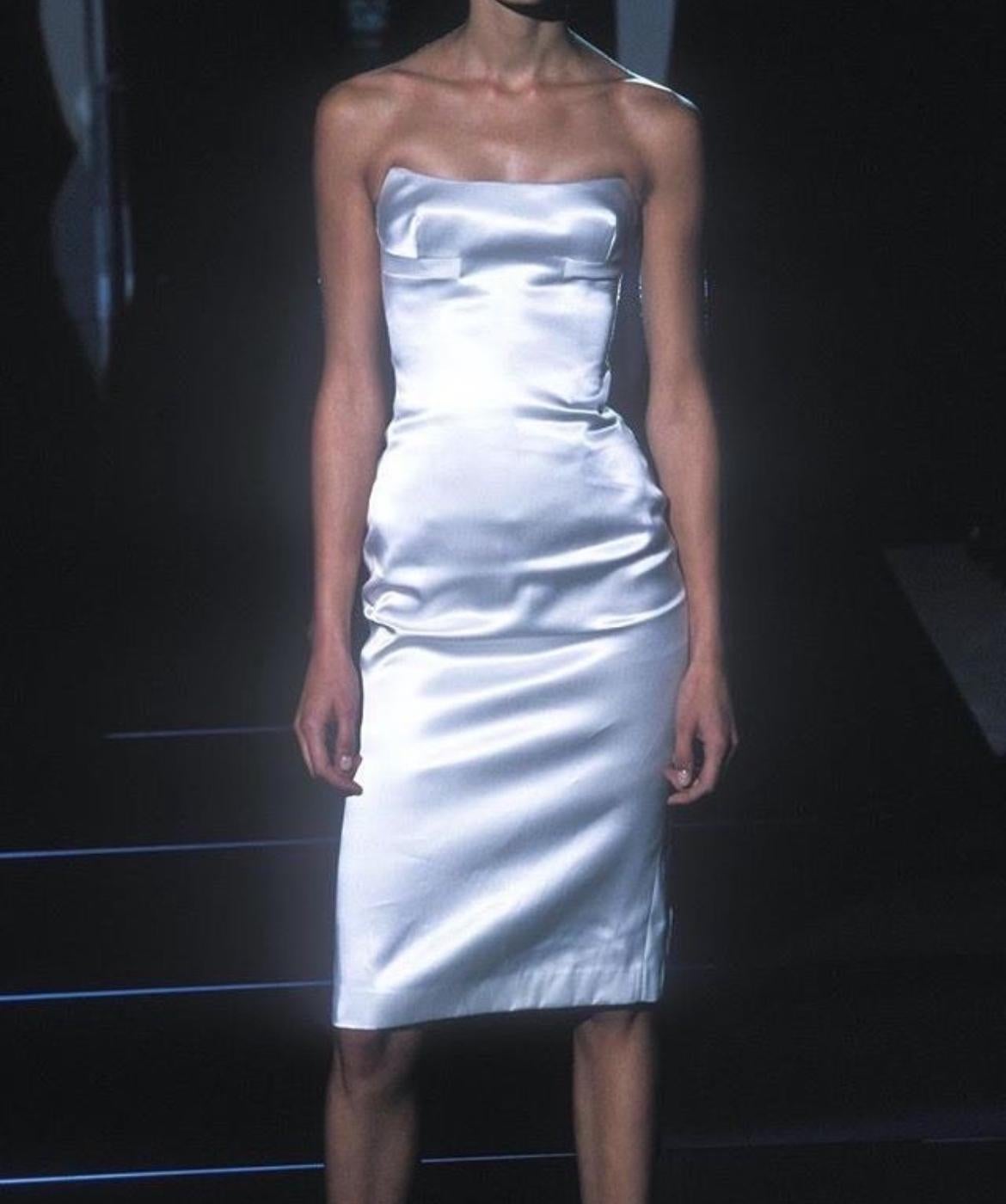 Sie präsentiert ein atemberaubendes trägerloses weißes Gucci Kleid aus Seidensatin, entworfen von Tom Ford. Dieses Kleid aus der Kollektion Frühjahr/Sommer 2001 war sowohl auf dem Laufsteg als auch in der Werbekampagne der Saison mit Kate Moss zu