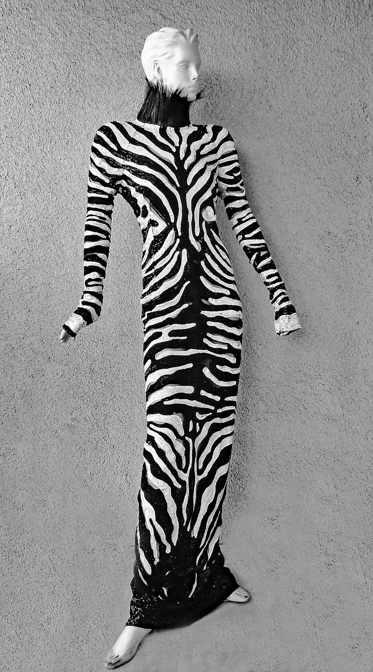 Striking and stunning Tom Ford vintage black and white hand-beaded gown designed in a Zebra pattern.  Trimmed in genuine ostrich feathers at neckline, and back.  Long sleeves with zipper wrists. Back high slit.  Also includes black silk halter