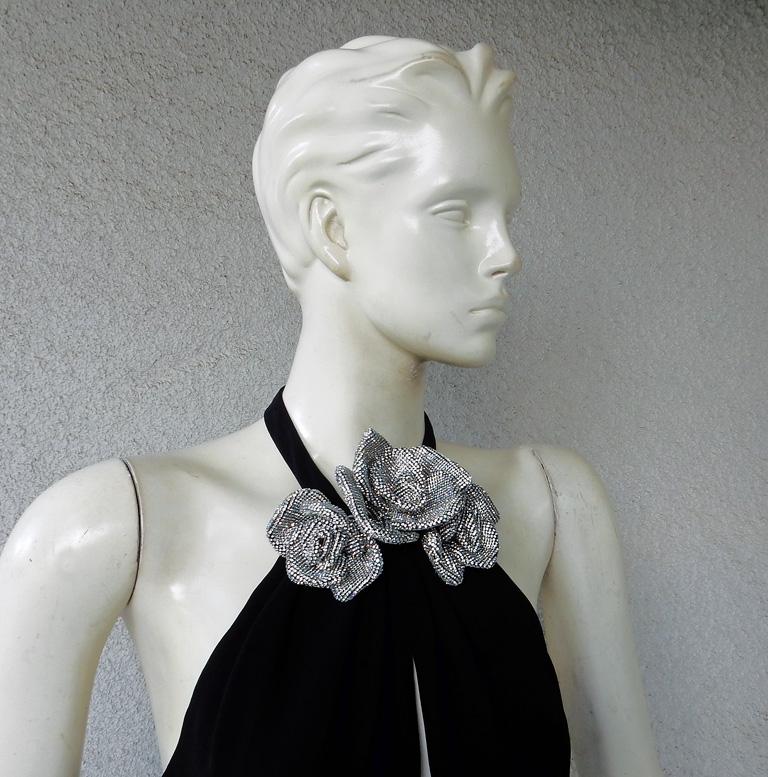 Uno splendido abito da ingresso di Valentino in seta nera con cavezza.  Lo stile del taglio in sbieco drappeggia il corpo senza sforzo e con eleganza.  Schiena aperta  con chiusura a bottoni sul retro della scollatura.  Chiusura con cerniera