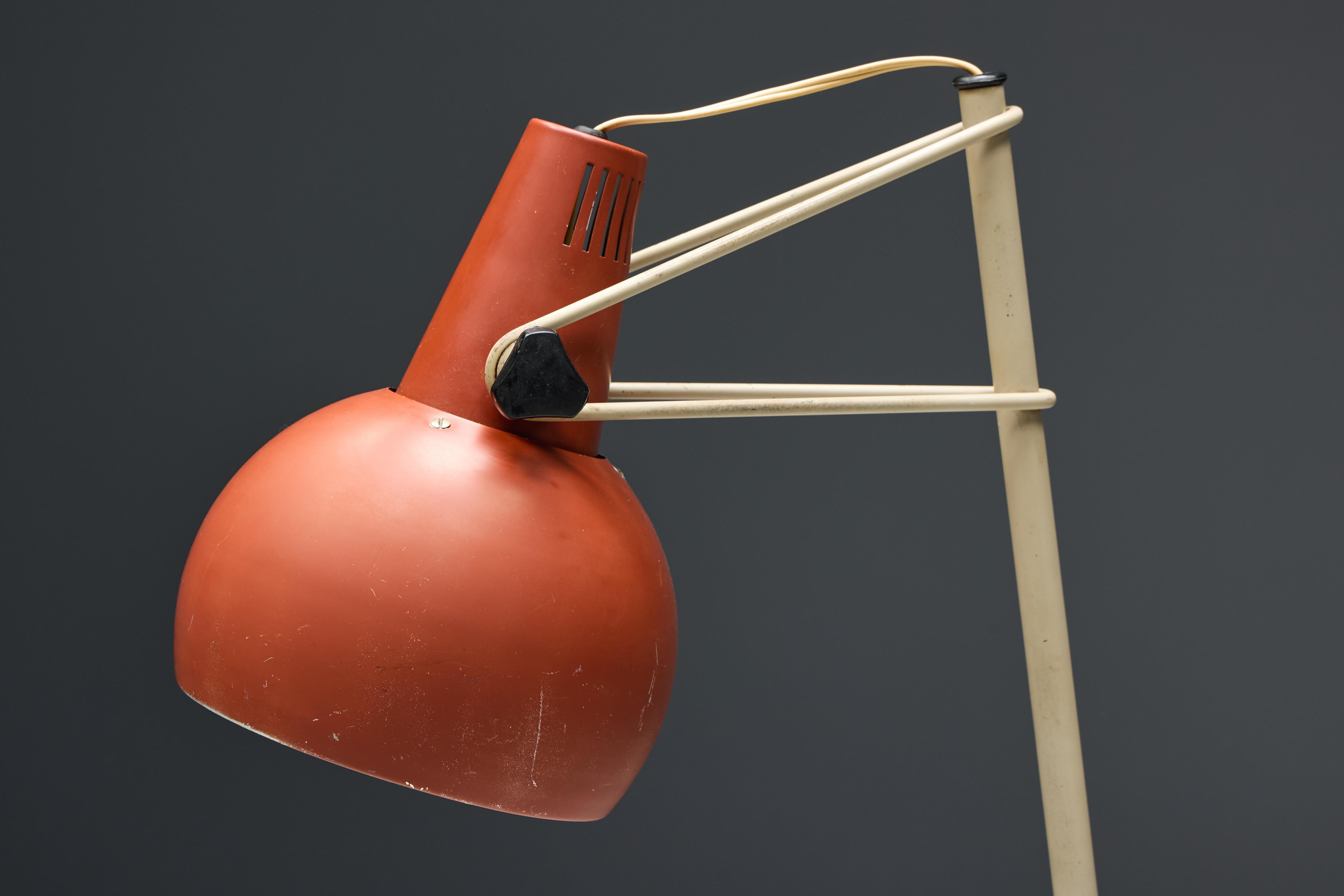 The 'NX29' floor lamp by Louis Kalff for Philips is a rare and iconic example of post-war industrial Dutch design from the 1950s. Its sleek and minimalist form features a distinctive angled stand and an adjustable red shade. 