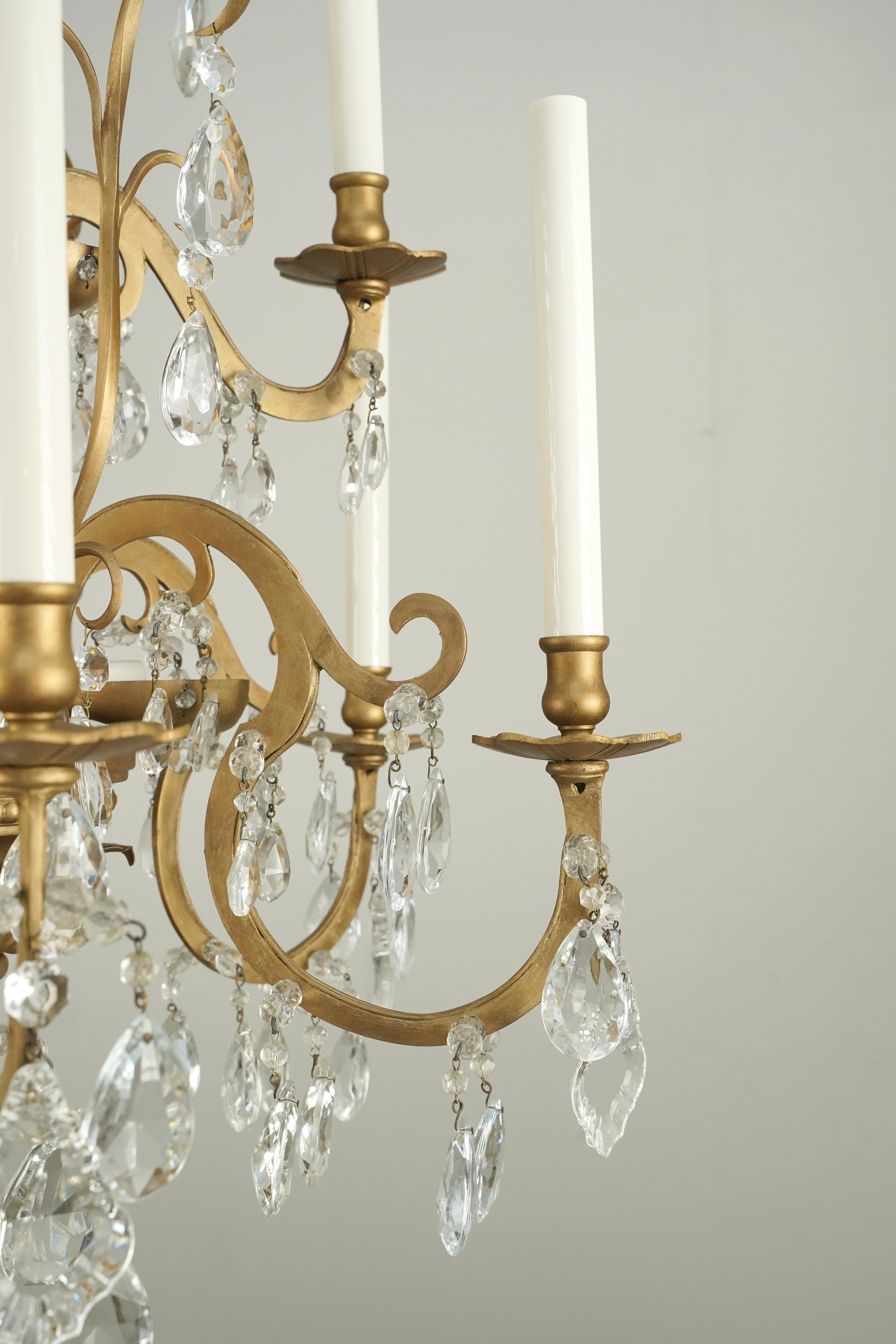 French Louis style two-tiered chandelier with leaf motifs. The crystals are faceted teardrops, floral rosettes, some with pink pearls embellished, and pendeloque shapes. The chain is made of steel with a bronze finish. This is original to the Plaza