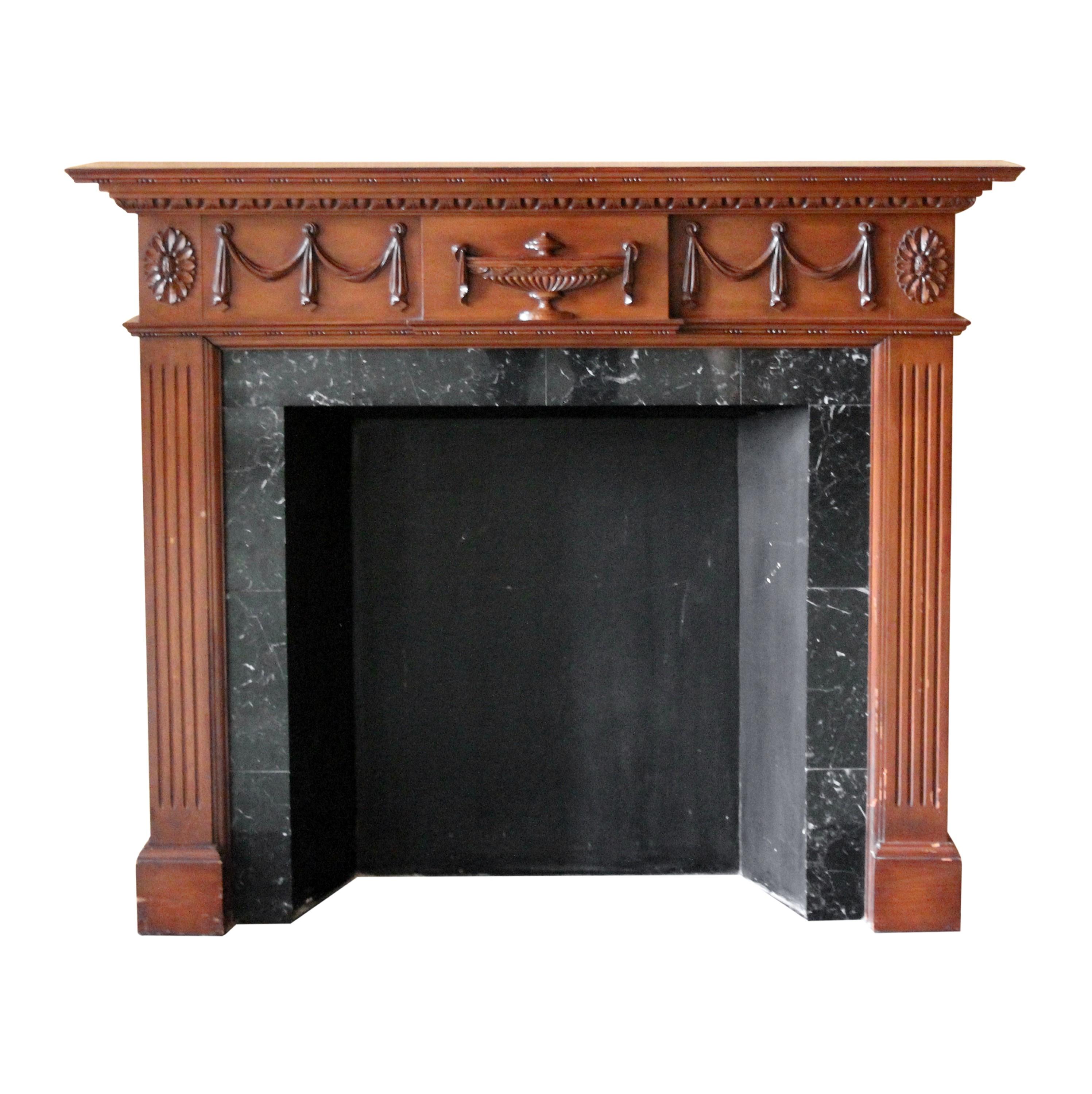 Ornate carved wood mantel from the famous NYC Waldorf Astoria Hotel featuring a dark tone natural finish. There are urn, ribbon, floral and egg & dart details and fluted columns. Unfortunately doesn't include the marble insert or the hearth. This is