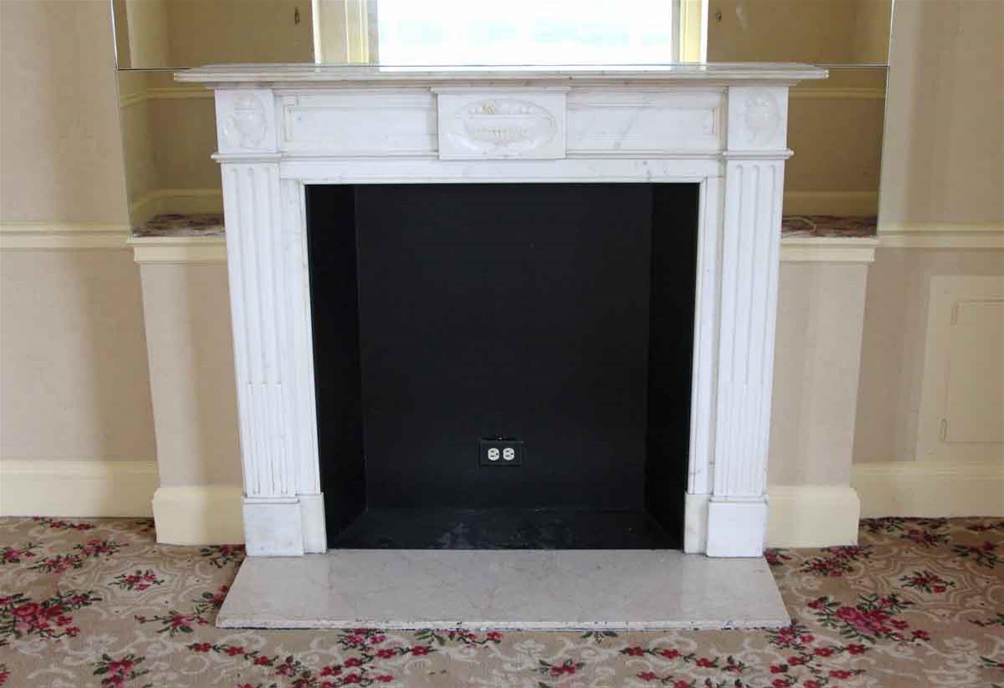 English Regency white statuary and Carrara marble mantel with urn details, circa 1910. This mantel was one of a group of antique mantels imported from Europe and installed in the NYC Waldorf Astoria hotel in the 1930s when the hotel was first built