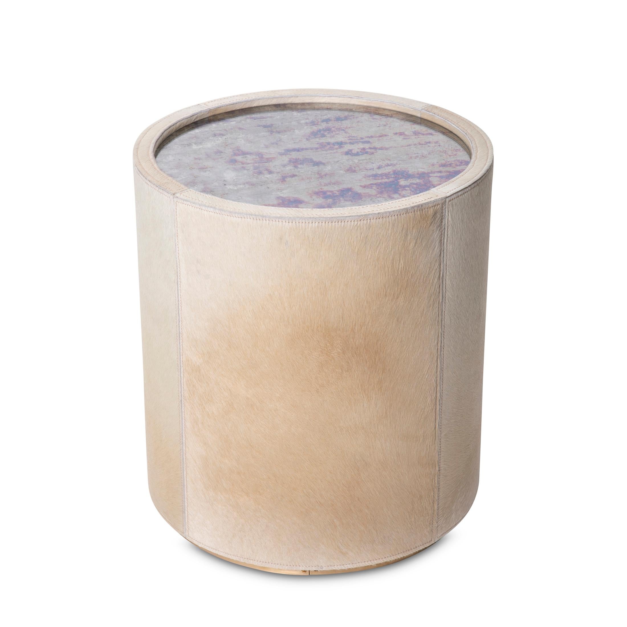 La table à boire en verre teinté Nyla définit l'opulence, enveloppée de manière exquise dans un luxueux poil sur peau. Cette pièce étonnante combine sans effort l'allure d'un miroir antique avec la sophistication d'un cuir de vachette crème.