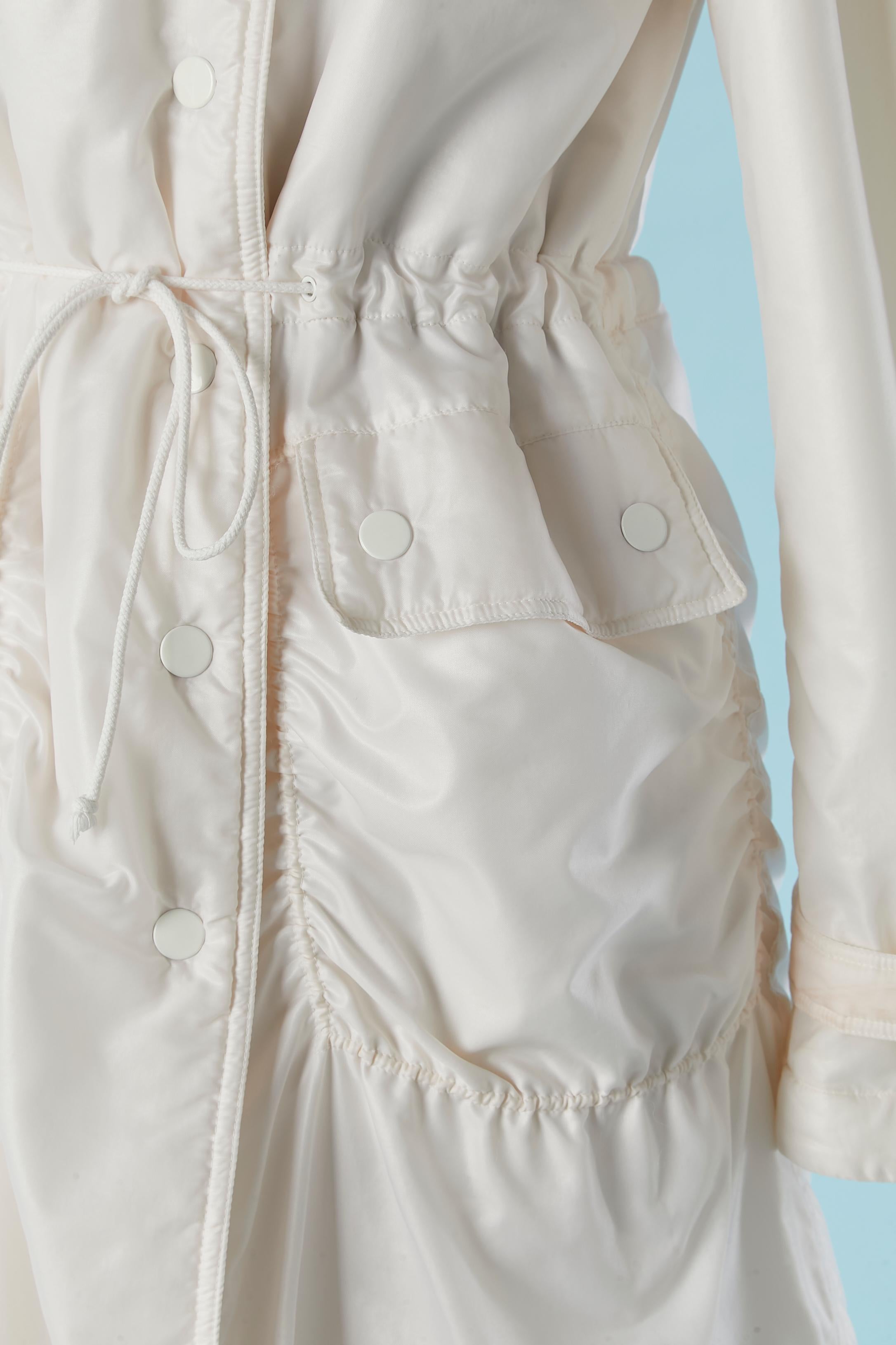 Nylon coat with faux fur lining and hood . Shell fabric composition: 100% polyamide ( nylon) . Lining composition ( faux fur) : 100% acrylic 
Drawstring waist. Pocket with snap closure. Split on the middle back with snap closure. Gathers around the