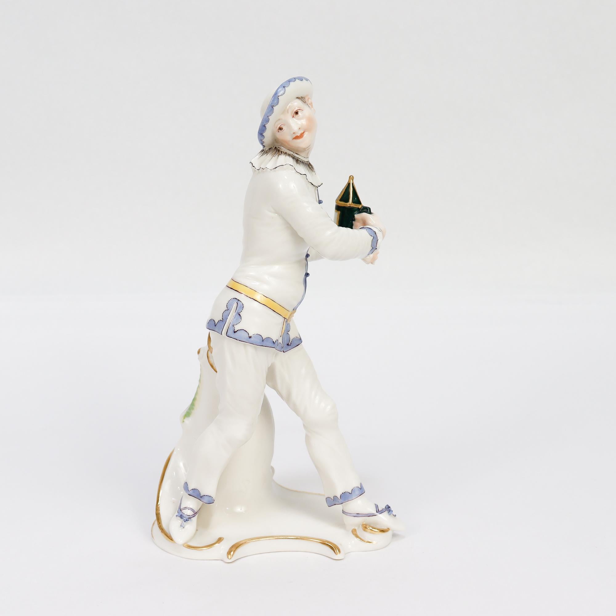 Une belle figurine en porcelaine peinte et dorée représentant le personnage de la commedia dell'arte, Pierrot. 

Par Nymphenburg. 

Pierrot représenté la tête sur le côté, en bleu, noir et or, et tenant une lanterne verte.

Modélisé à l'origine par