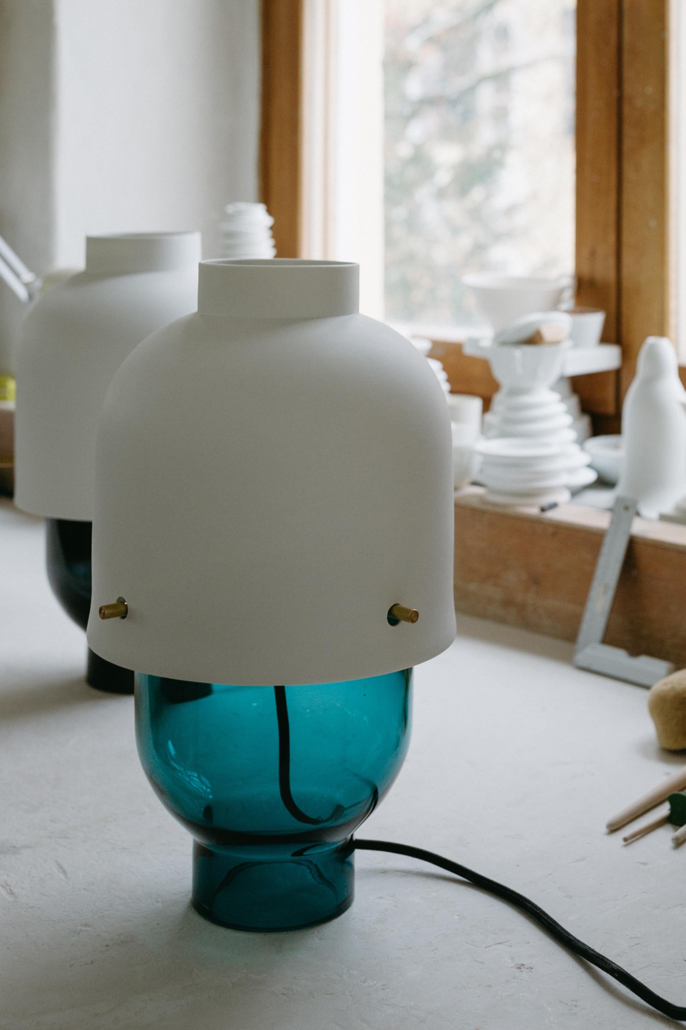 Questa lampada da tavolo artigianale è una combinazione di materiali pregiati in una composizione moderna. La porcellana Nymphenburg Porcelain ha creato una tonalità di porcellana traslucida che non ha rivali. Combinato con un piede in vetro