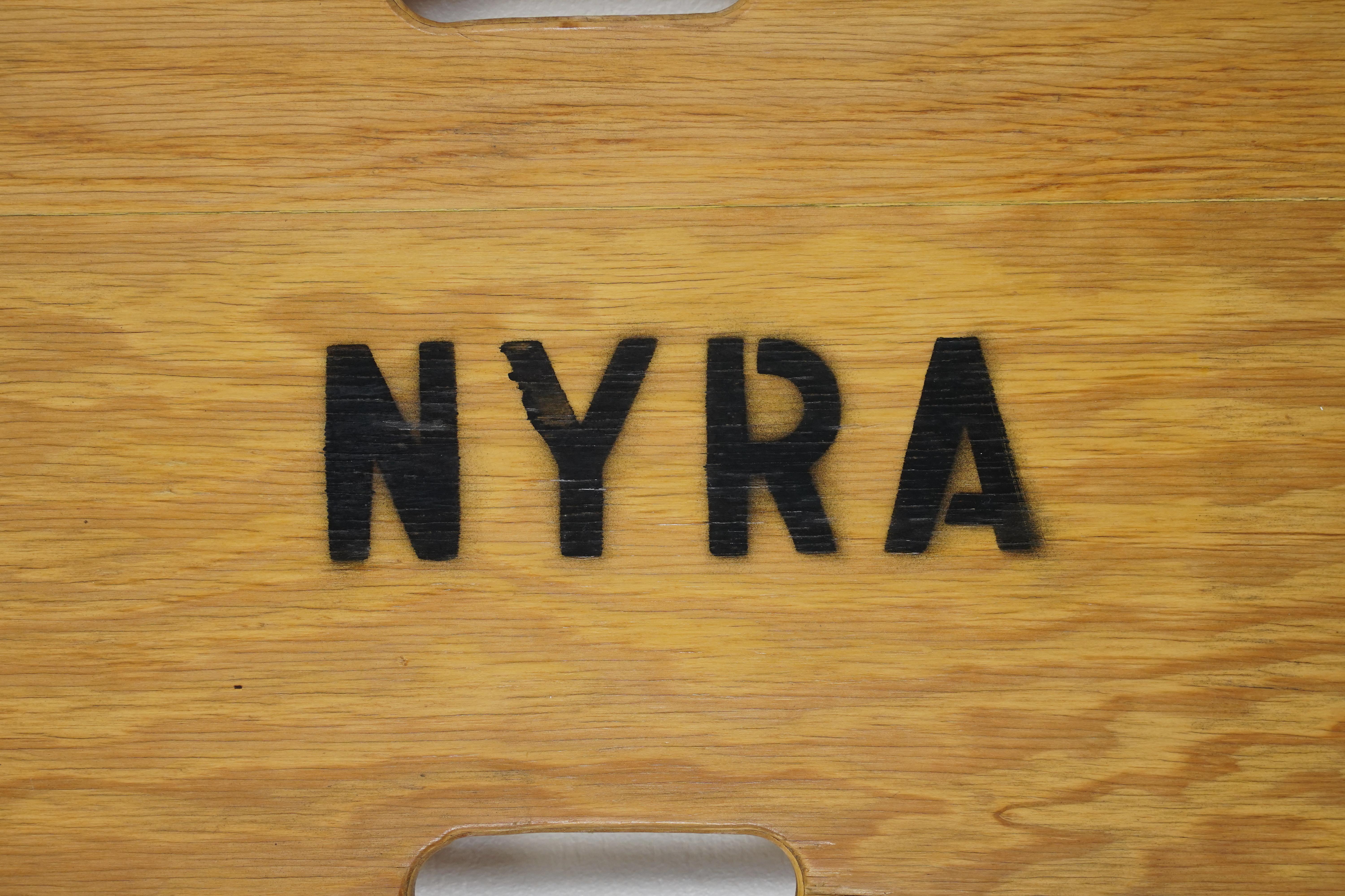 From the Belmont Park Racetrack in Elmont, New York. It is referred to as a spine board and is used for emergency medical services. The piece is made of light tone wood. Two fasteners for straps are included. It is inscribed NYRA, which stands for