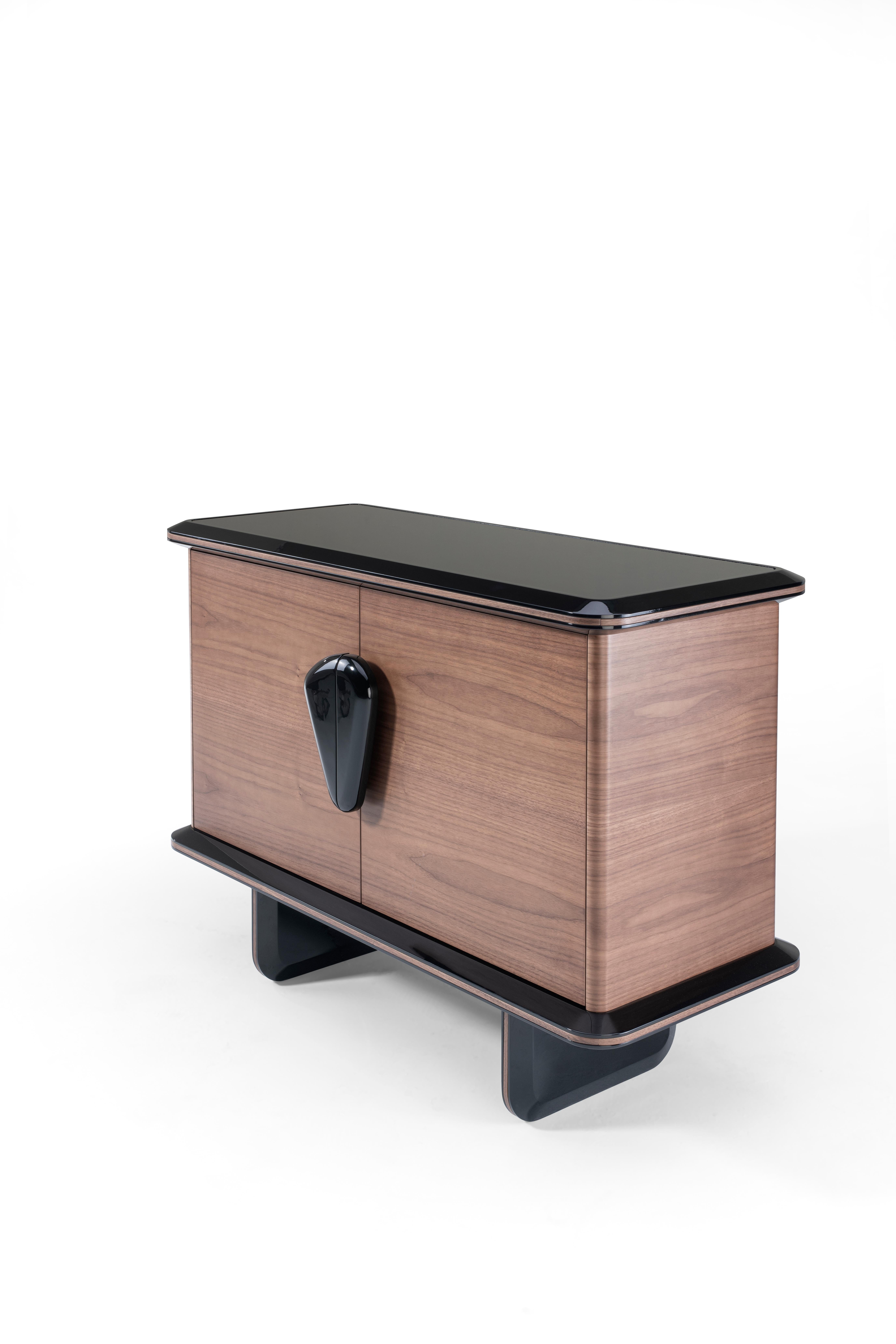 The N’ZUZI 2-door sideboard is a piece of furniture with an original and unique design. Its distinctive shape has rounded corners adorned by black glass on top. The exclusive design of the handles brings sophistication to this piece of furniture,