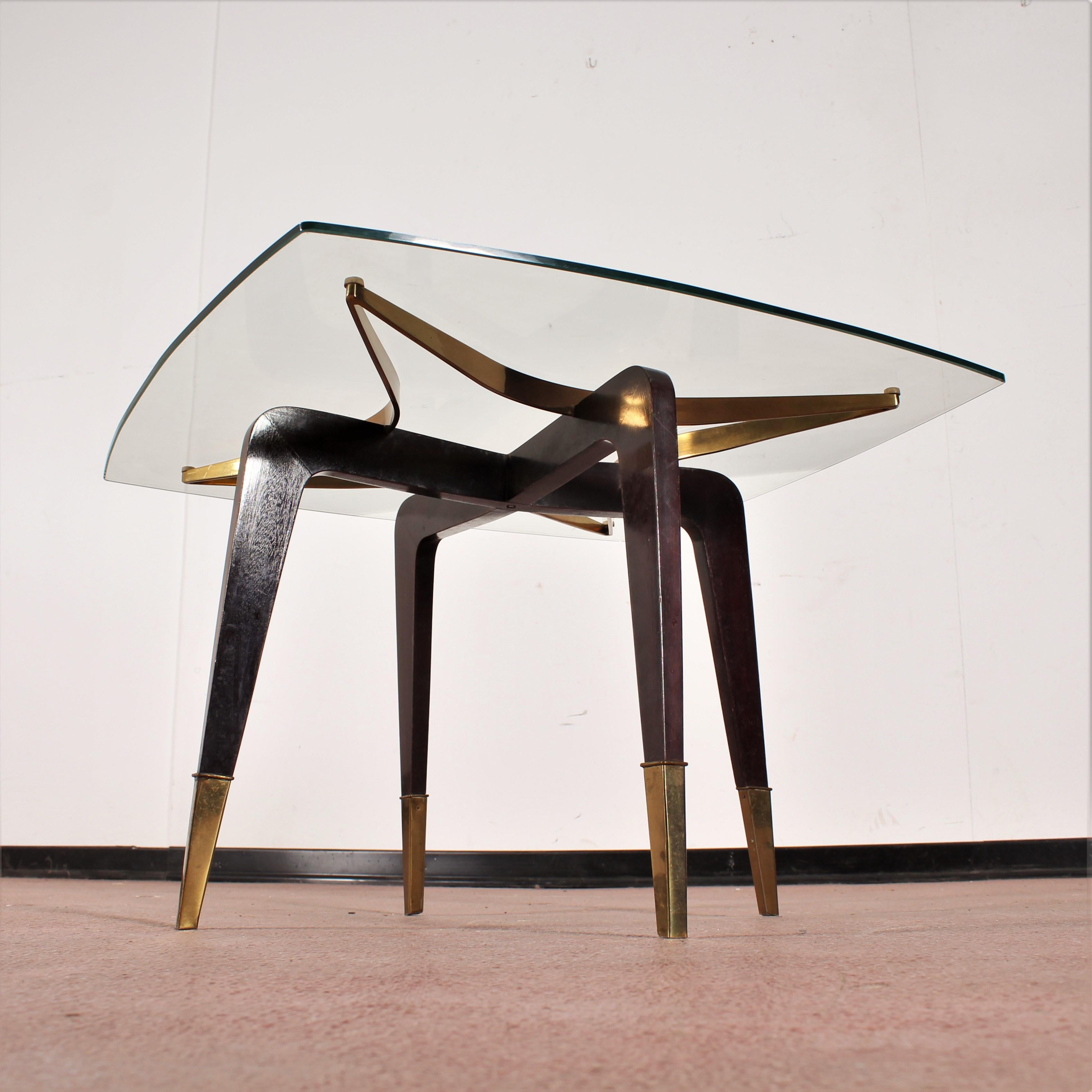 Very beautiful brass and wood square coffee table clear glass top.
Stylish star shaped brass support embedded in the cross of the wooden and brass legs offers an extraordinary optical effect. Attributed to Osvaldo Borsani, Italy, 1950s.
Wear