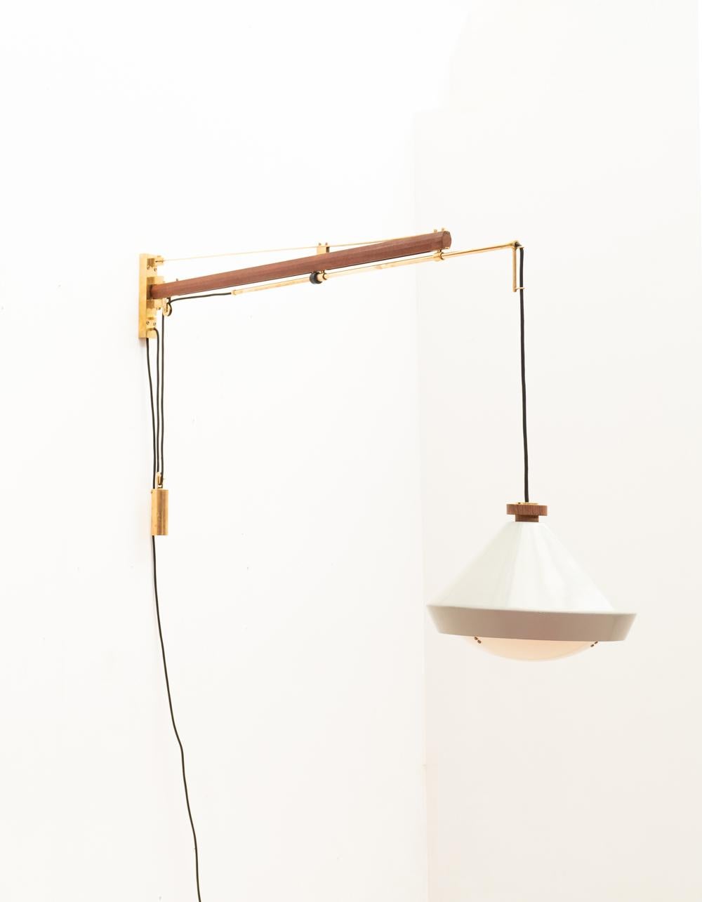 Crafted in 1957 by O-Luce in Italy, the Tito Agnoli Mod. 177A wall lamp exemplifies technical design and material refinement. With teak, solid brass, enameled aluminum, and white acrylic, it epitomizes elegance.

Its ingenious construction allows