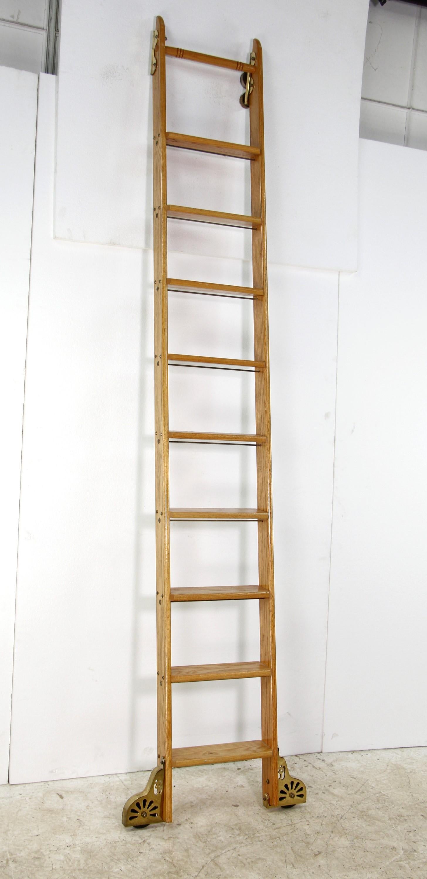 Mid-20th Century oak library ladder in a light stain. Features brass plated steel hardware and rolling wheels. Missing one set of top rolling wheels. Made by Putnam Rolling Ladder Co., Inc.
