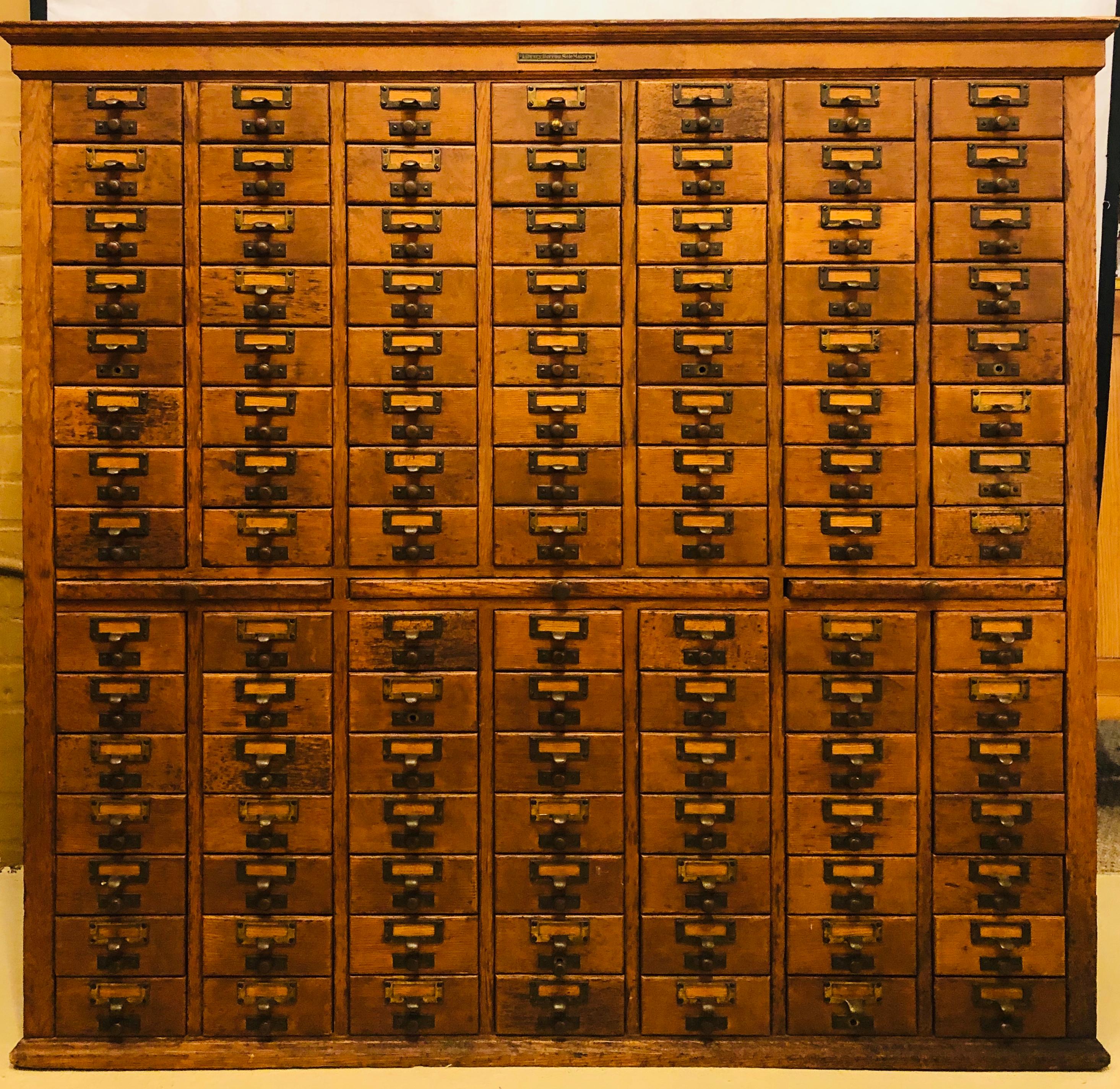 Oak 1920s library bureau sole maker card catalog cabinet. This is a large and impressive 105 drawer double cabinet on cabinet. This piece is an antique library bureau sole makers (SoleMakers) 60-drawer library card catalog (also known as filing