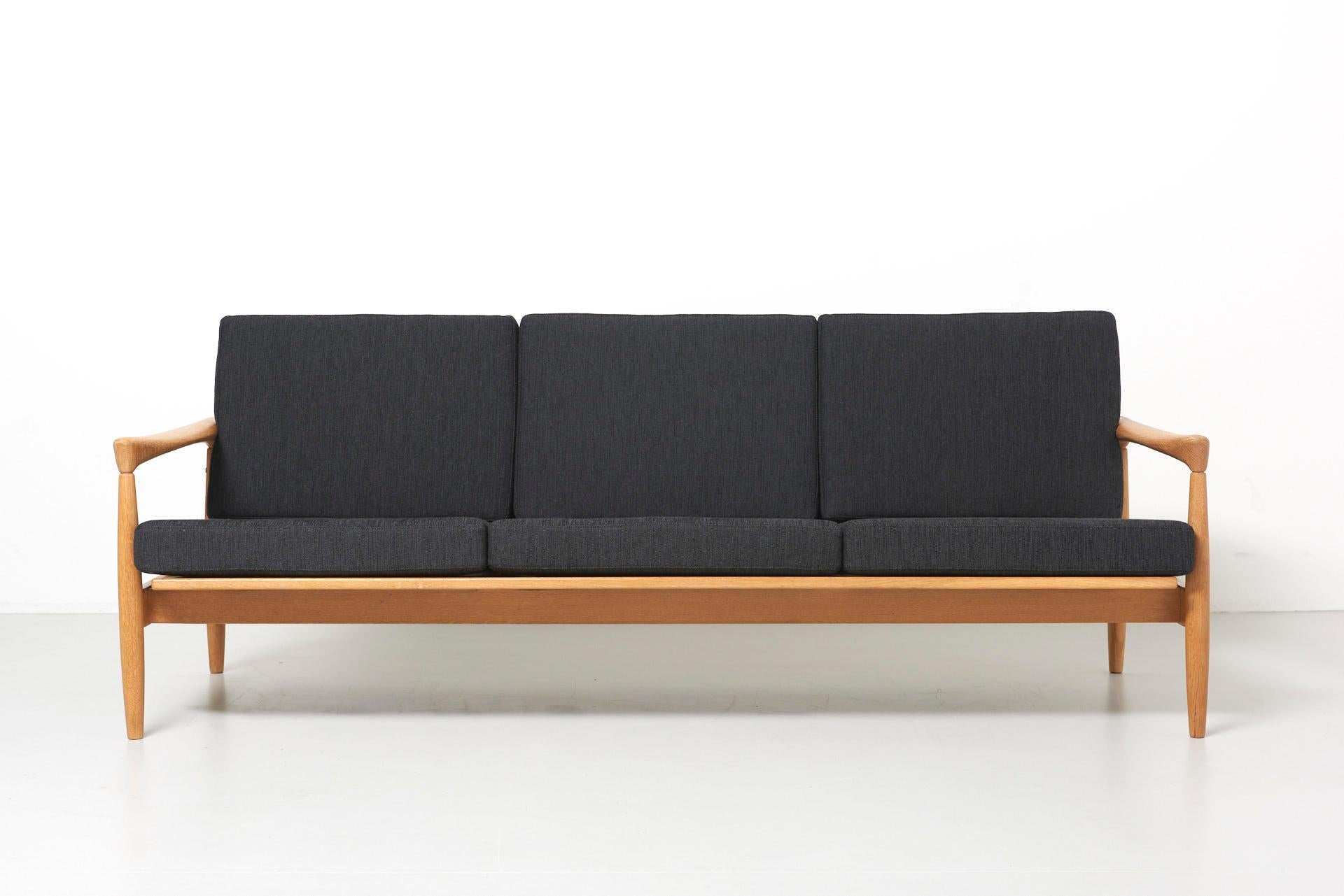 A sofa in oak with new black coushins.
