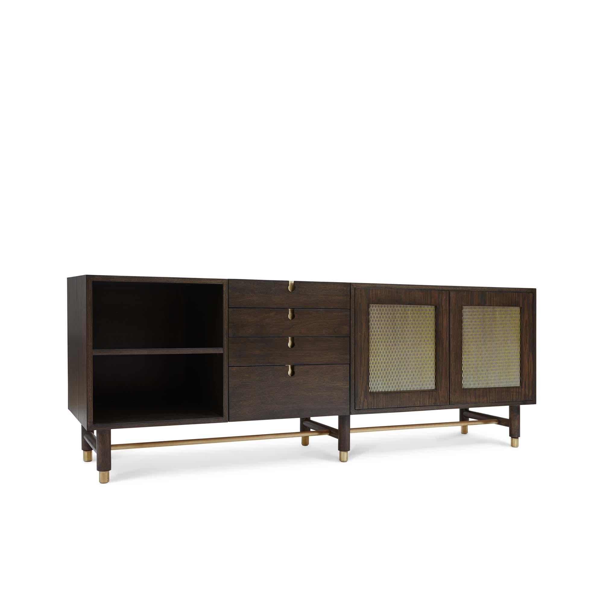 The Niguel Credenza features brass cap feet, a brass cross-stretcher bar and brass inlaid details with brass mesh sliding bypass doors. Shown here in dark grey washed oak and satin brass. 

Oak and brass niguel credenza by Lawson-Fenning.

The