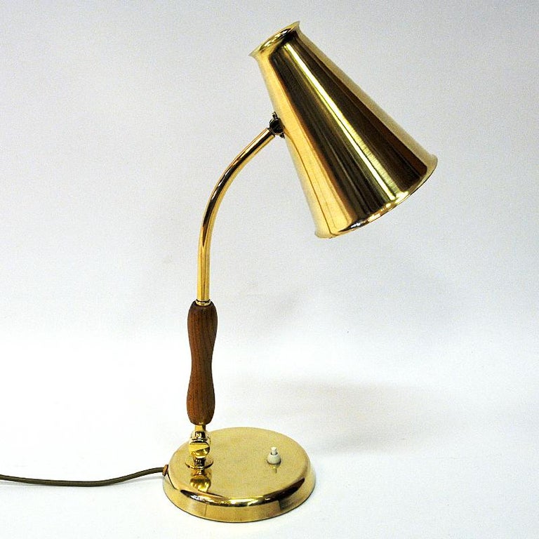 Lovely oak and brass table lamp mod E1318 probably by Hans Bergström for ASEA, Sweden, 1950s. Oak and brass pole, brass foot base with a light switch. Brass shade and body adjustable back and forth. Sculpted oak handle. Marked with model number and