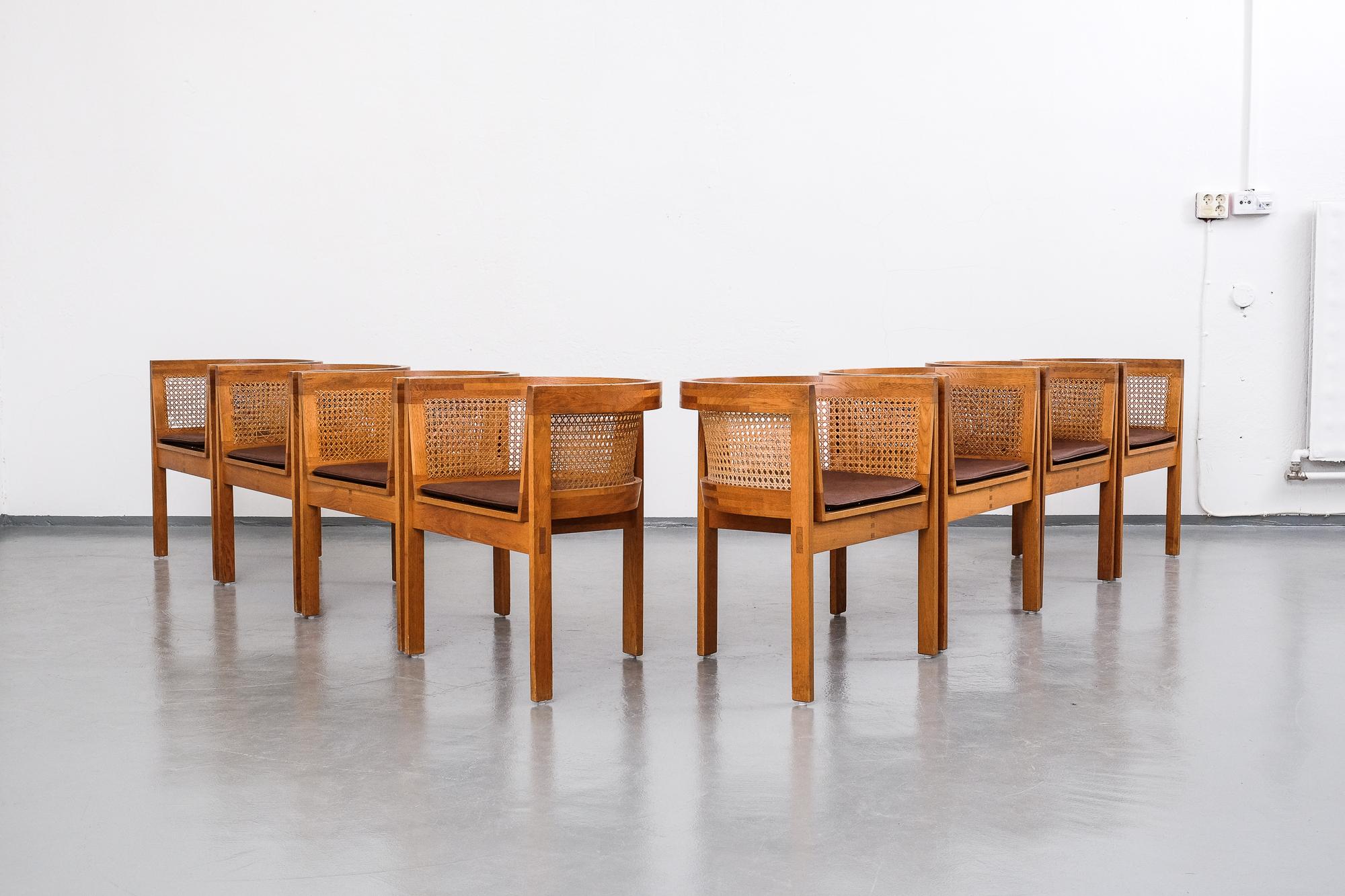 Rare set of 8 Danish dining chairs model 5, designed by Ilse Rix in 1961. Manufactured by Uldum Møbelfabrik. Armchairs with patinated oak frame. Seat, back and sides with cane webbing. New loose seat cushions upholstered with brown
