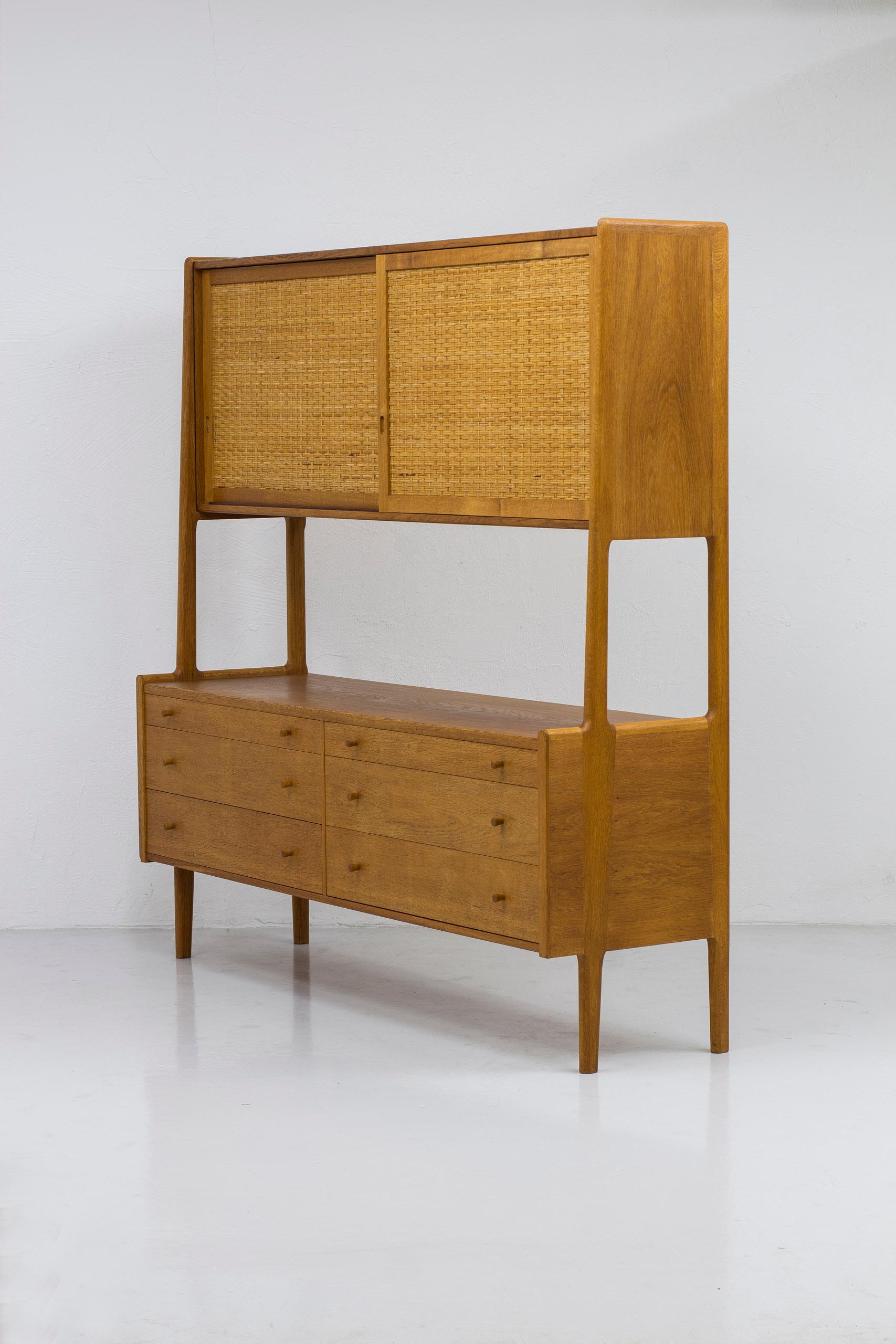 High board or double cabinet model RY20 designed by Hans J. Wegner. Produced in Denmark by RY Møbler, this example stamped February 1962. Made rom oak with contrasting cane on the upper sliding doors. Inside of the cabinet in light maple. Nice
