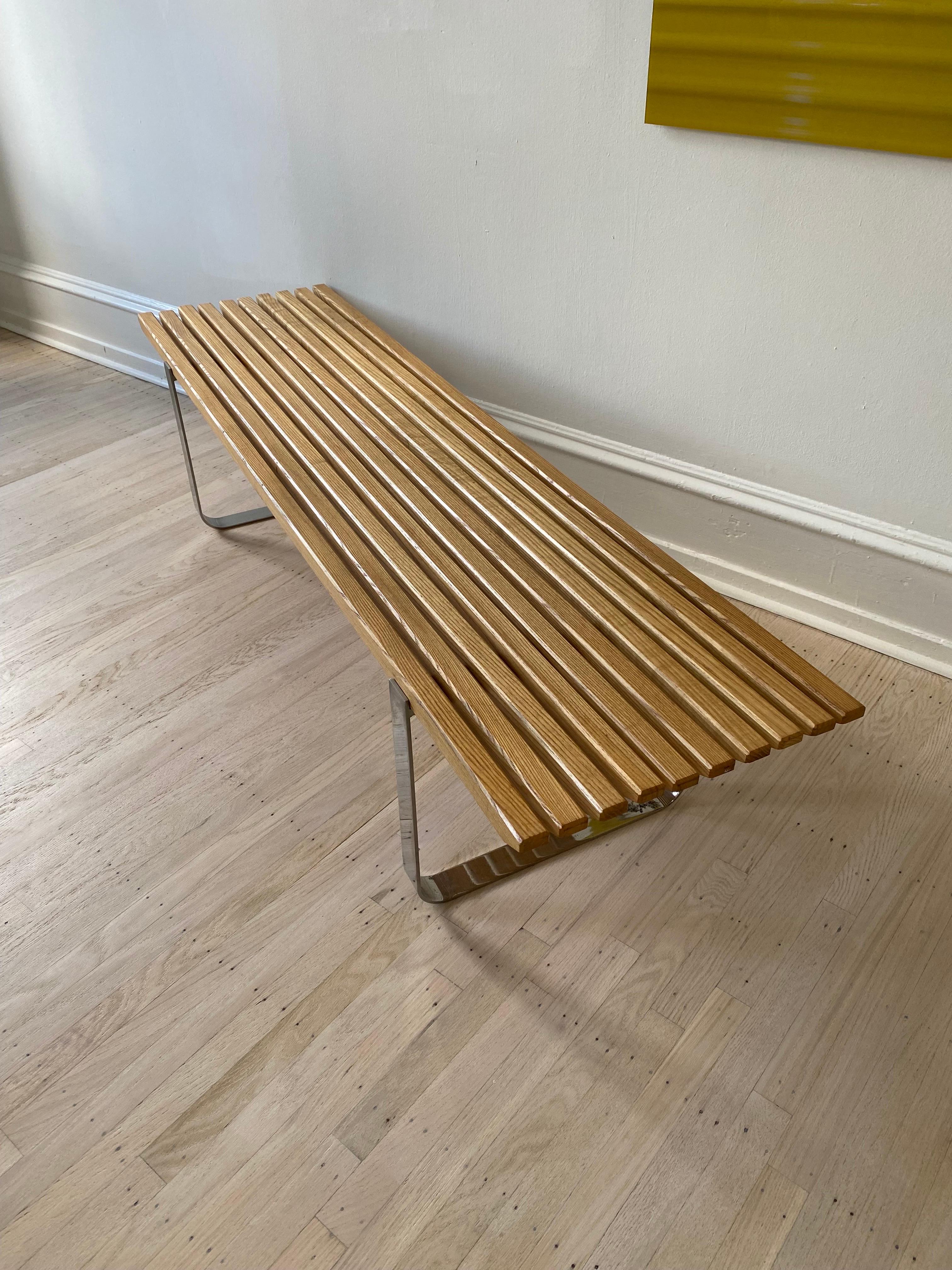 Oak Slatted Bench with a Chrome Frame. Simple sturdy design that looks great. Unsold Bench that had been hanging in a Furniture Warehouse in Philadelphia. Chrome on one leg shows some losses as seen in photo. Wood finish still looks great and