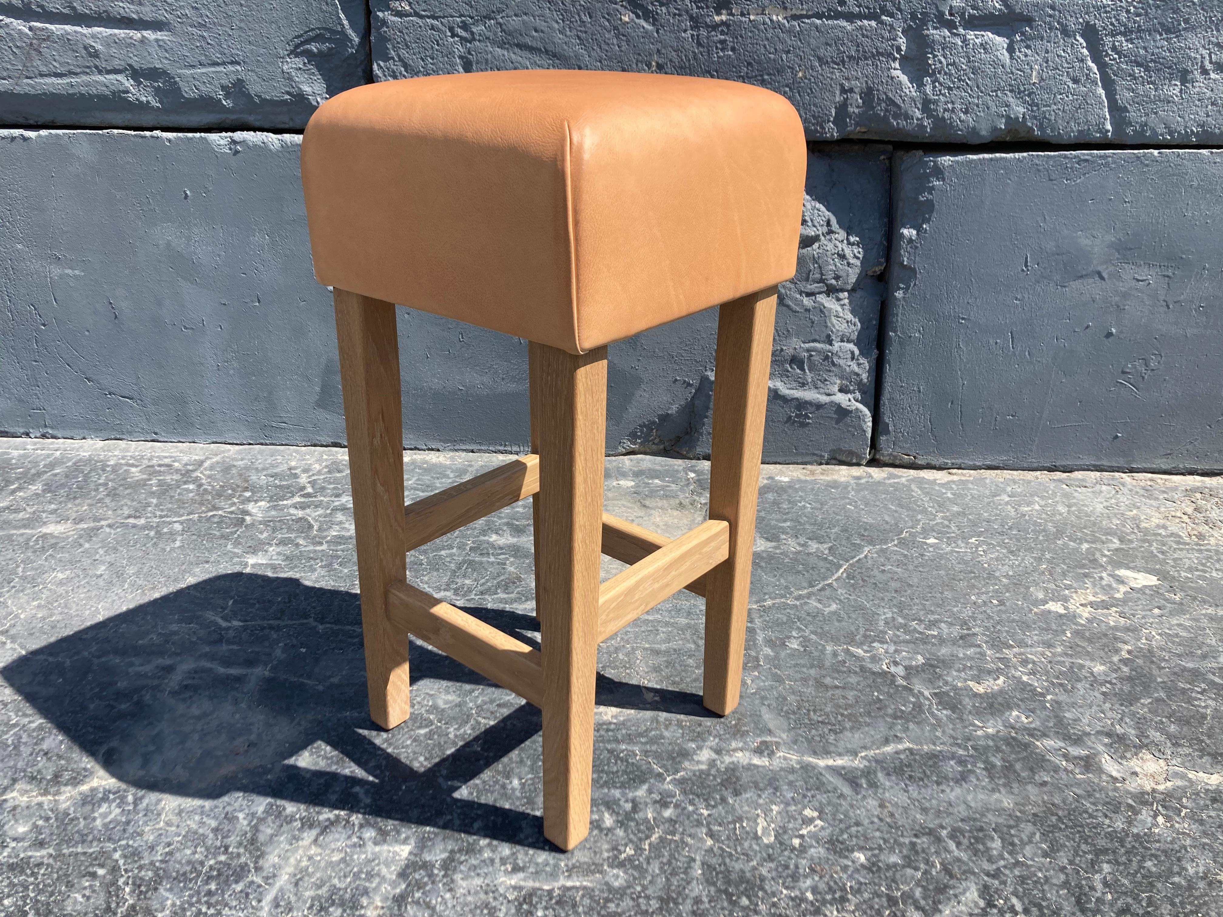 Beautiful barstools, pickled white oak base with clear lacquer finish and a vegetable tanned leather seat. The first picture shows a stool where the leather has aged, please see other pictures for current production. The Leather is very thick and