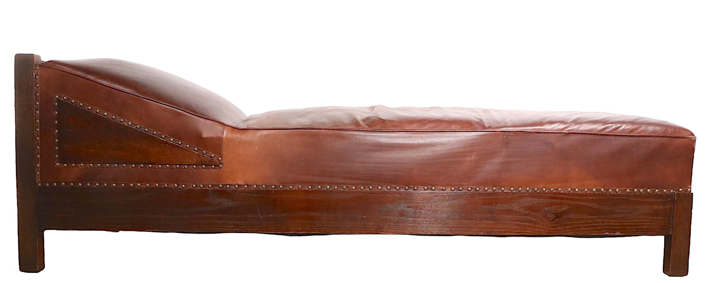Architectural Mission, Arts and Crafts daybed, chaise lounge, in solid oak and leather with brass nailhead trim. The chaise is in very good condition, we believe the leather upholstery is later, but not new. Bold, masculine lines, exceptional