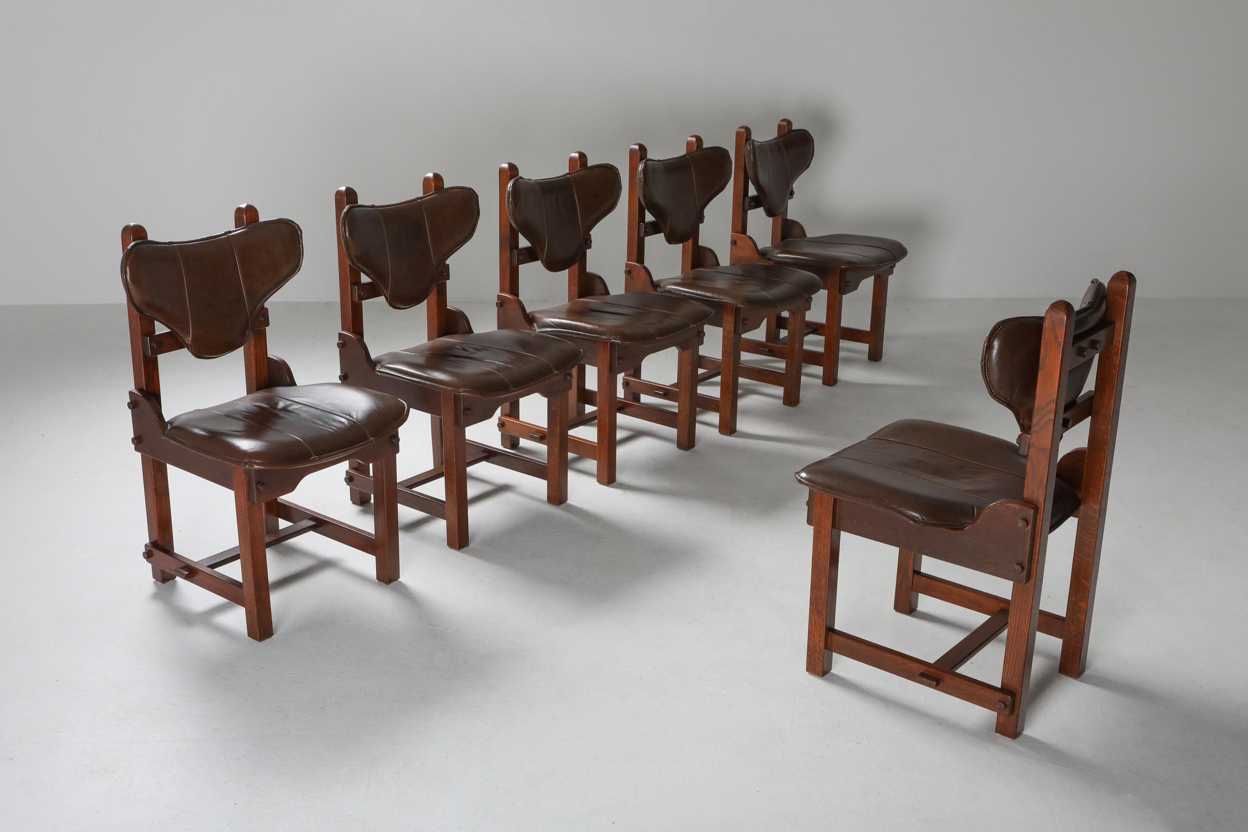 Brutalist set of six dining chairs in solid stained oak, original leather upholstery. 

Brutalism is an architectural style started from the mid-20th century, aiming for raw, geometric and compromise-less buildings. Characterised by blatant
