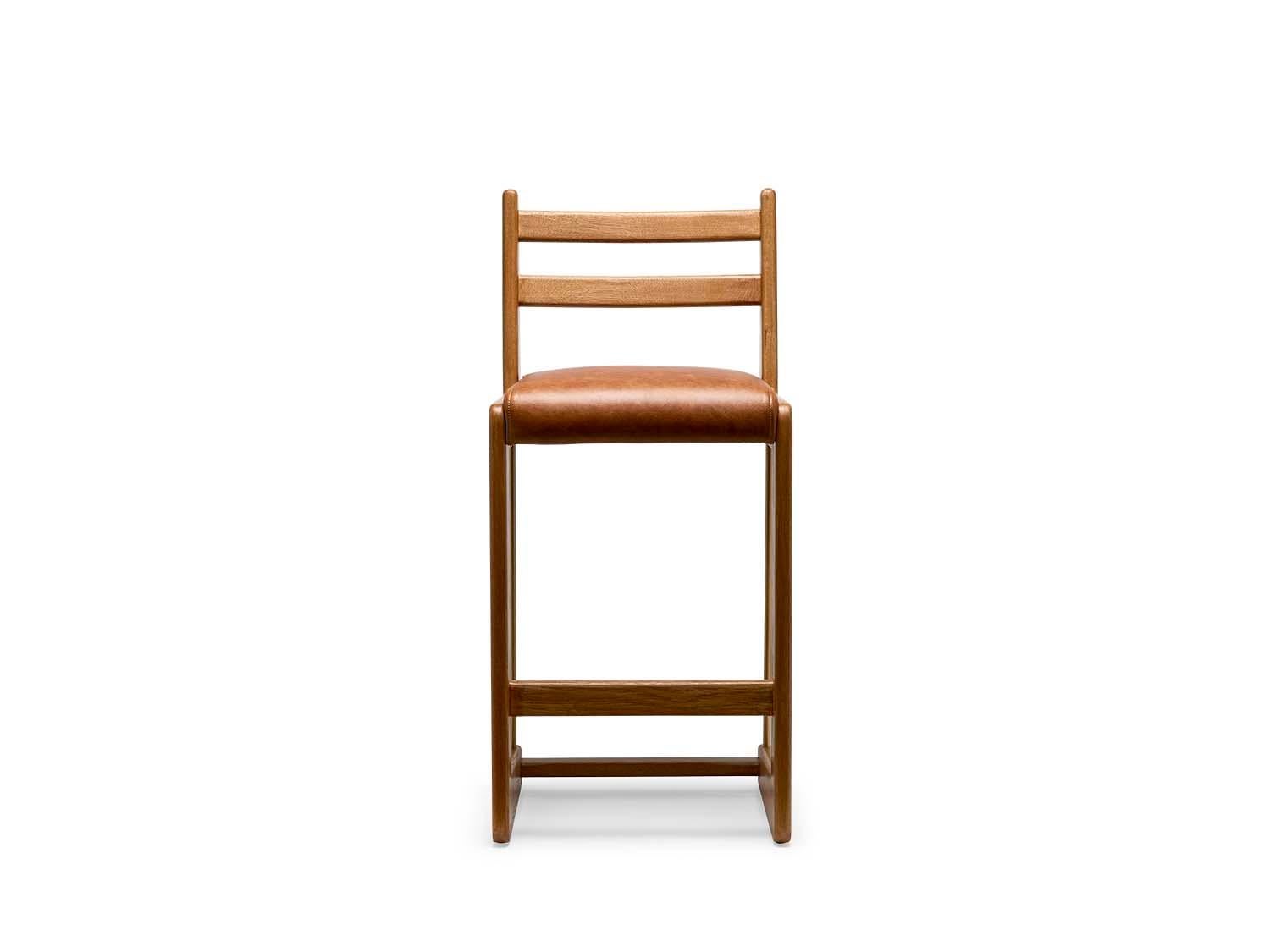 The Cruz barstool is made from a solid American walnut or white oak frame that features a cantilevered shape and lacquered brass stretchers. The seat is upholstered.

 