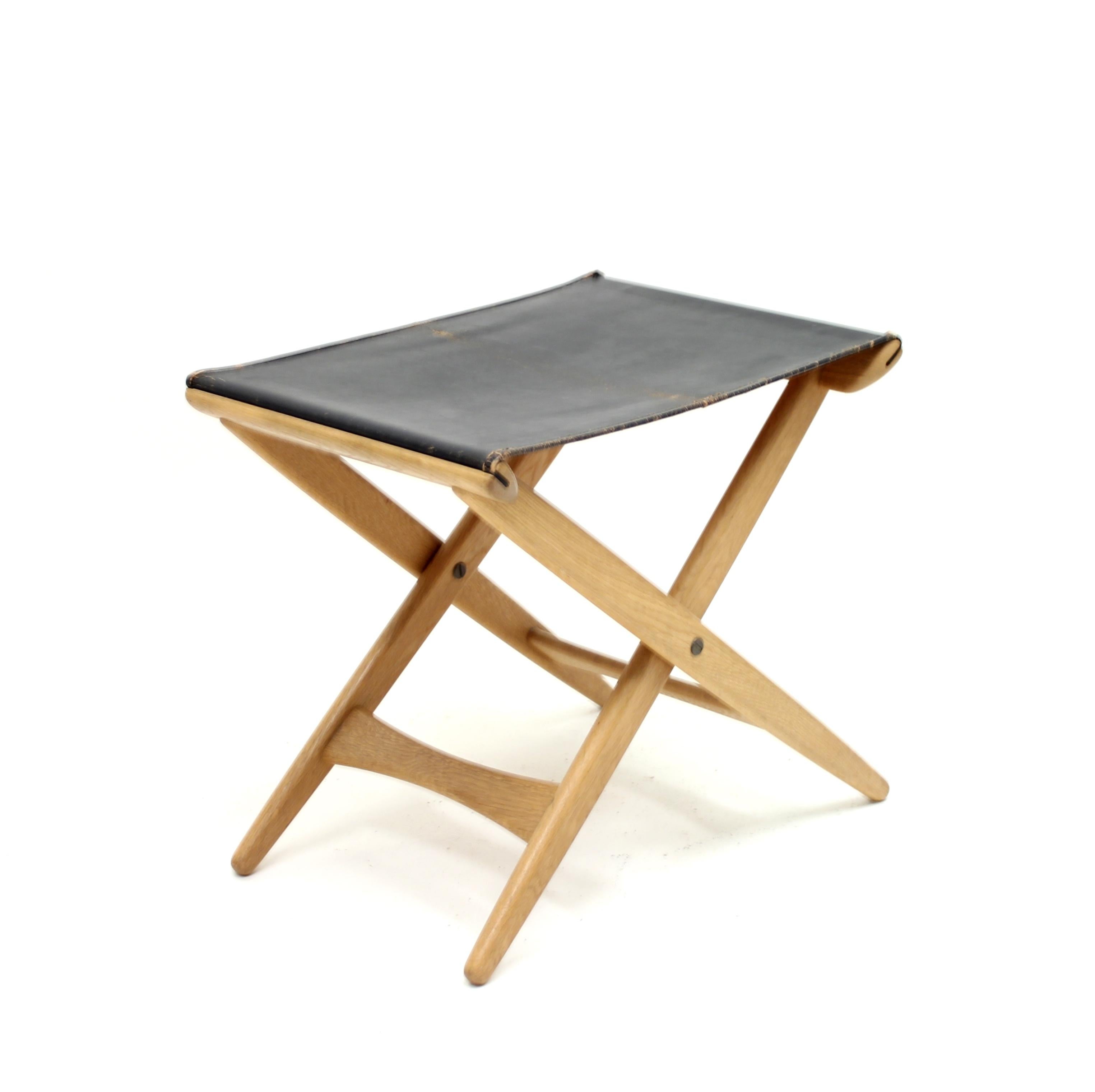 Folding stool designed by Östen Kristiansson for his own firm Luxus in the 1960s. Leather seat on an oak frame. Very good vintage condition with minor ware. A little bit of patina on the original leather.