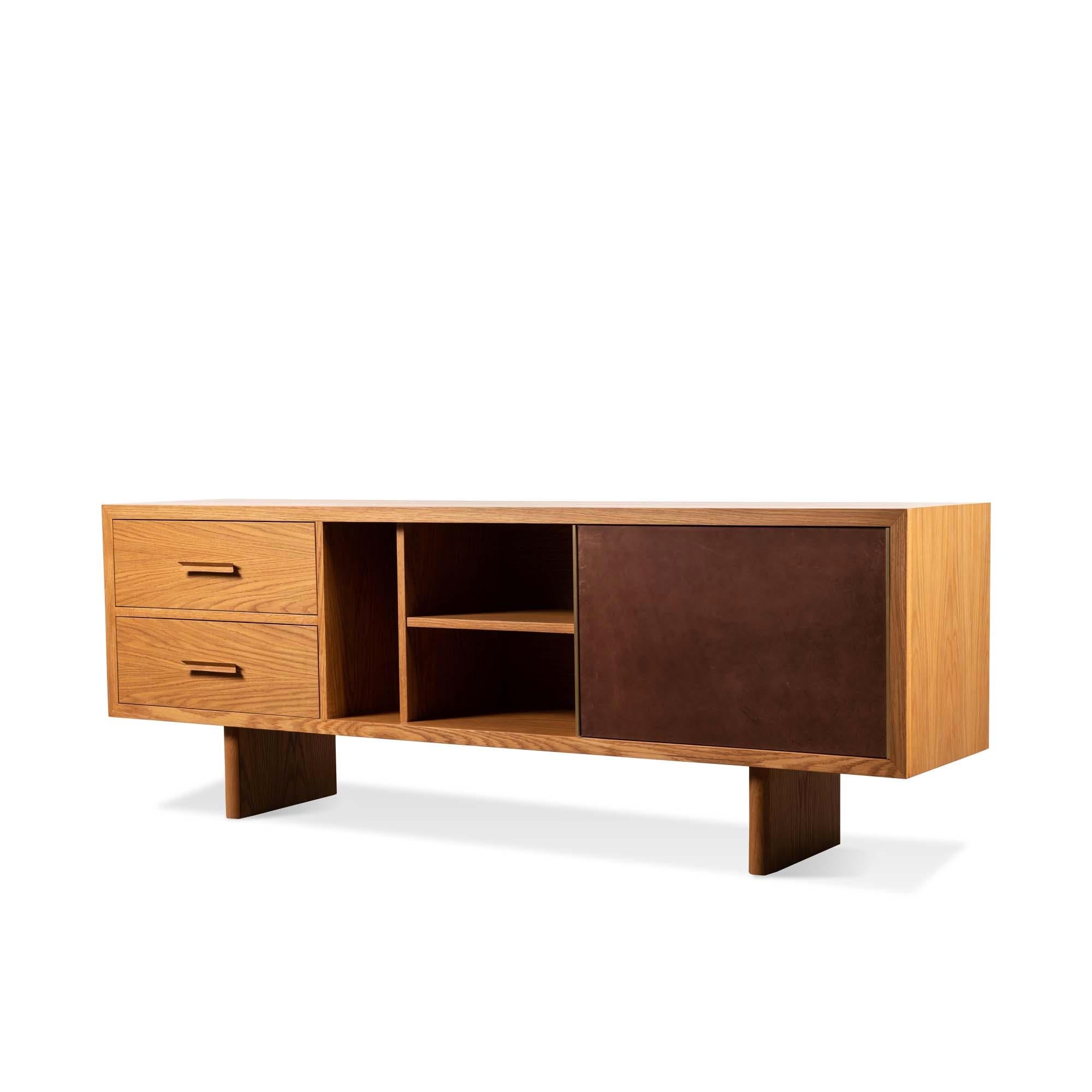 The inverness media cabinet features two drawers with solid carved handles, adjustable shelves, grommet holes and a sliding leather door with a solid brass handle. Available in American walnut or white oak. Wall-mounted version available. Specify at