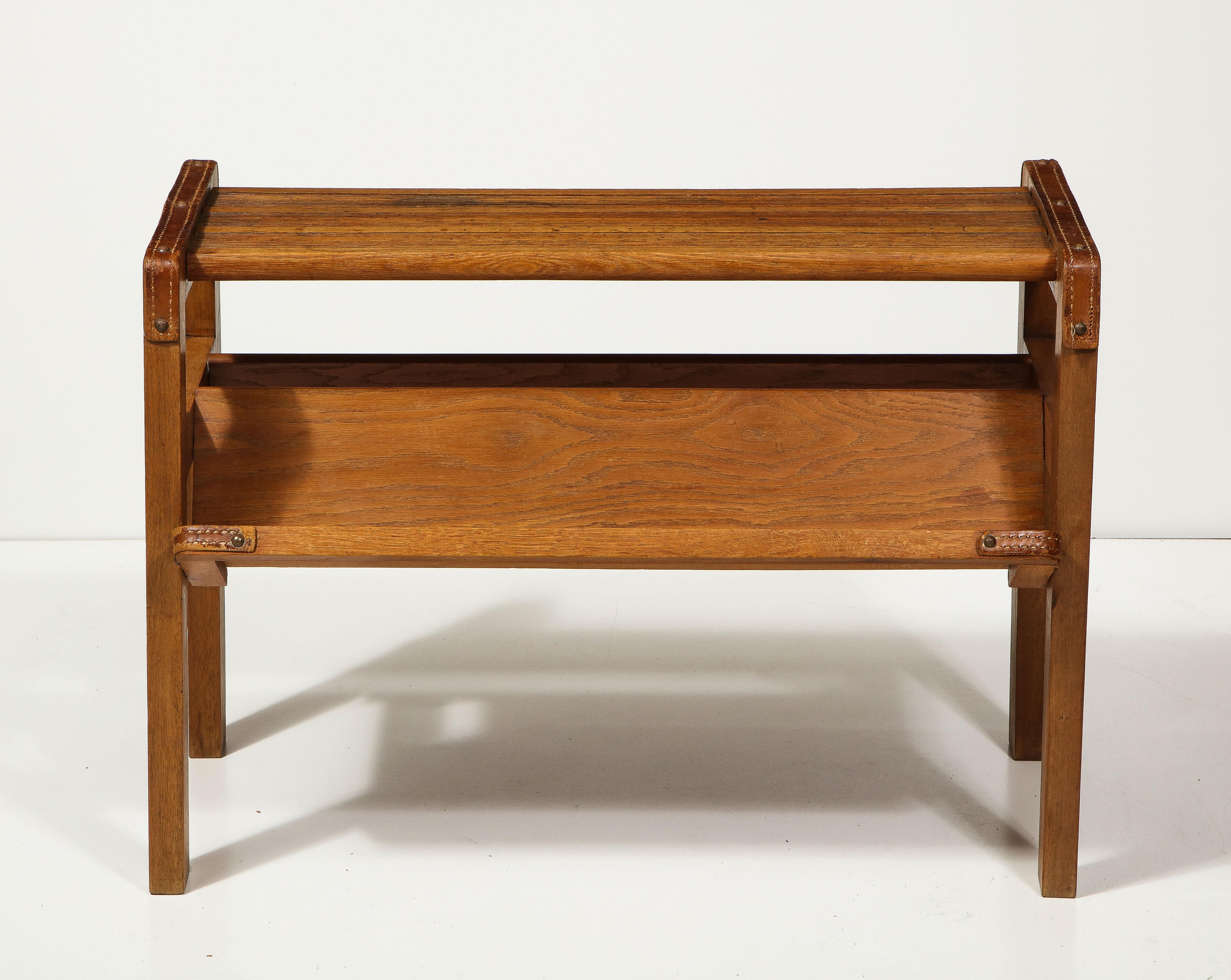 Oak and leather magazine rack by Jacques Adnet, France, c. mid-20th century.

This iconic magazine rack consists of a solid oak construction, an angular frame, and handsome leather details typical of Adnet's design.