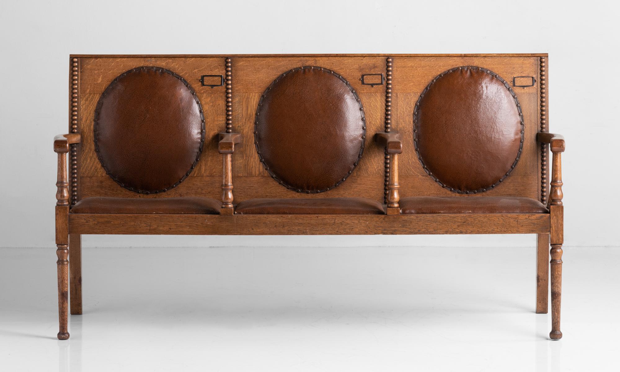 Oak and leather settle, Scotland, circa 1900

Solid oak construction with leather upholstered backs, originally from a synagogue.