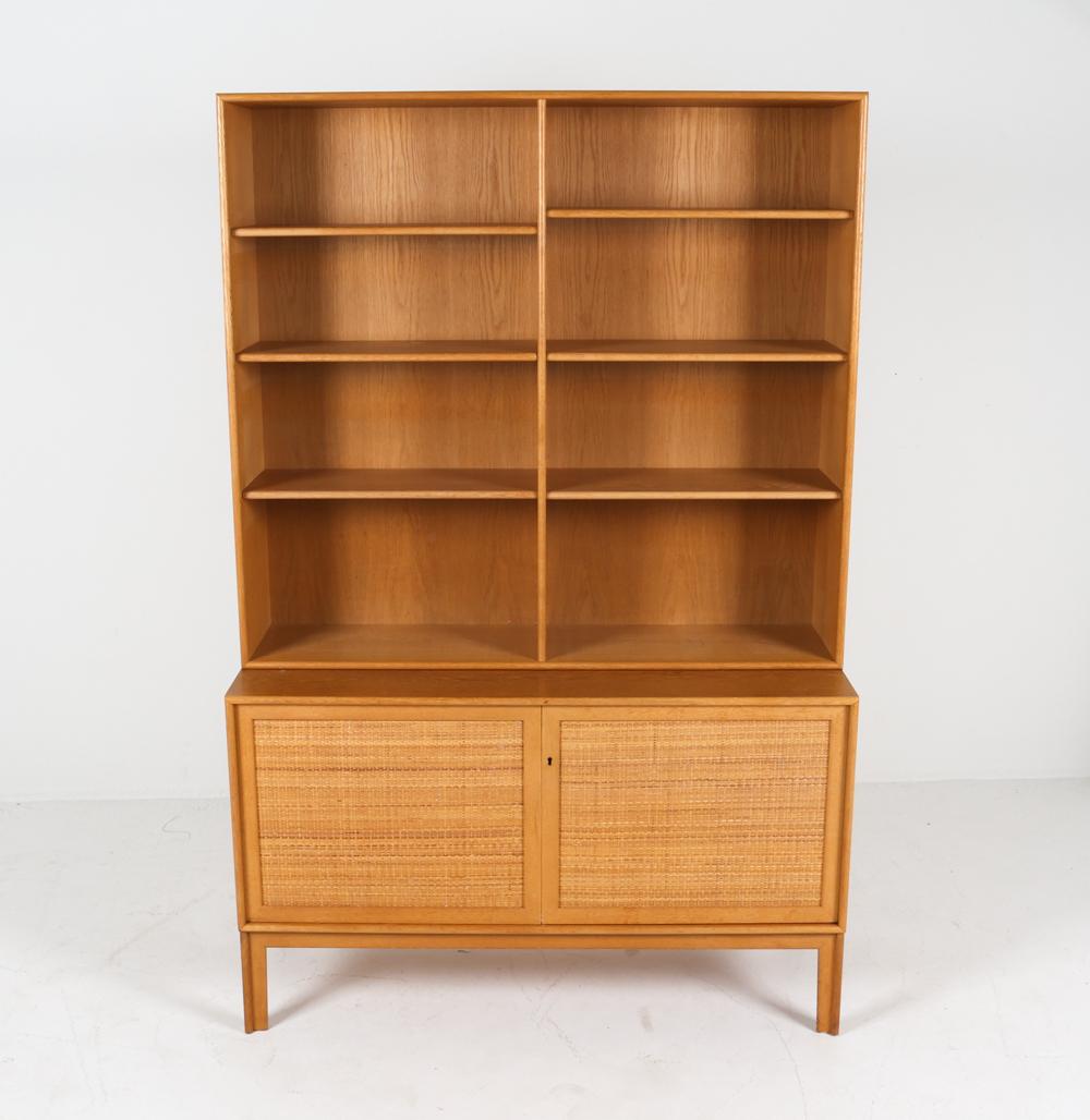 Exemple étonnant du design suédois du milieu du siècle, cette armoire-bibliothèque en retrait a une allure impressionnante. Fabriqué en beau chêne blond, il présente un aspect net et accueillant, qui ne manquera pas de se faire remarquer et