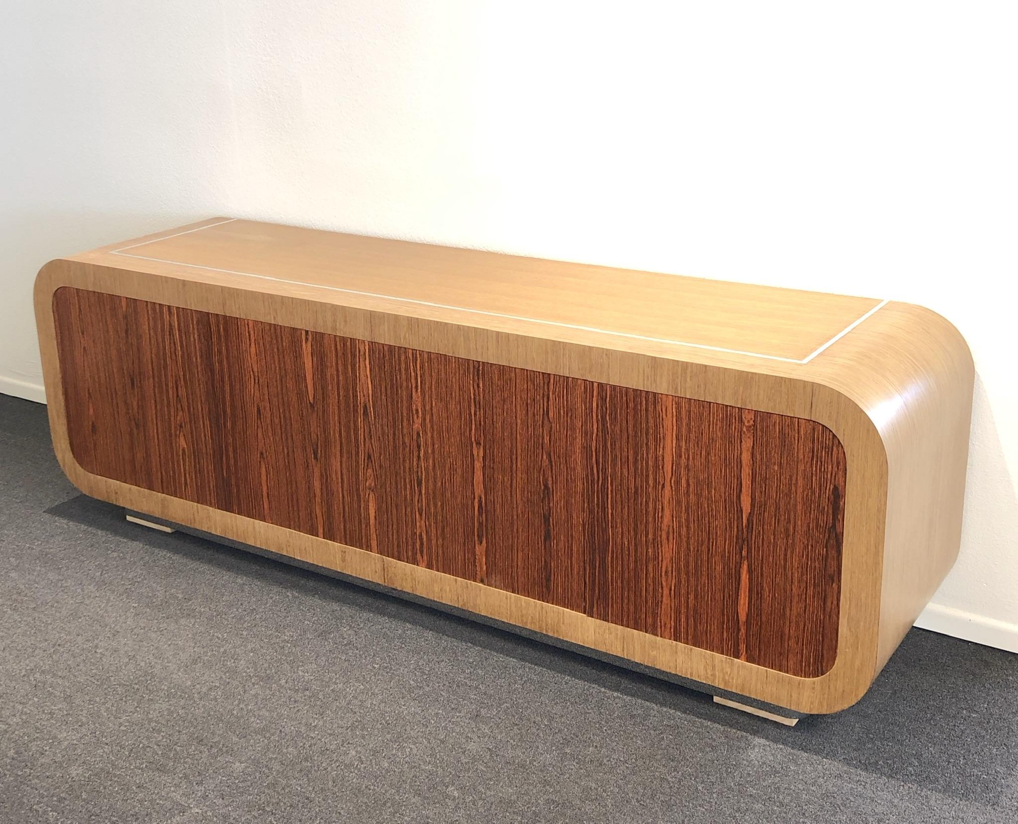 A spectacular custom made credenza design in the 1980’s by Steve Chase for a project in Mission Hill Country Club. The credenza is constructed of oak and rosewood veneer with polish chrome inlaid on top and base. The piece is very heavy and well