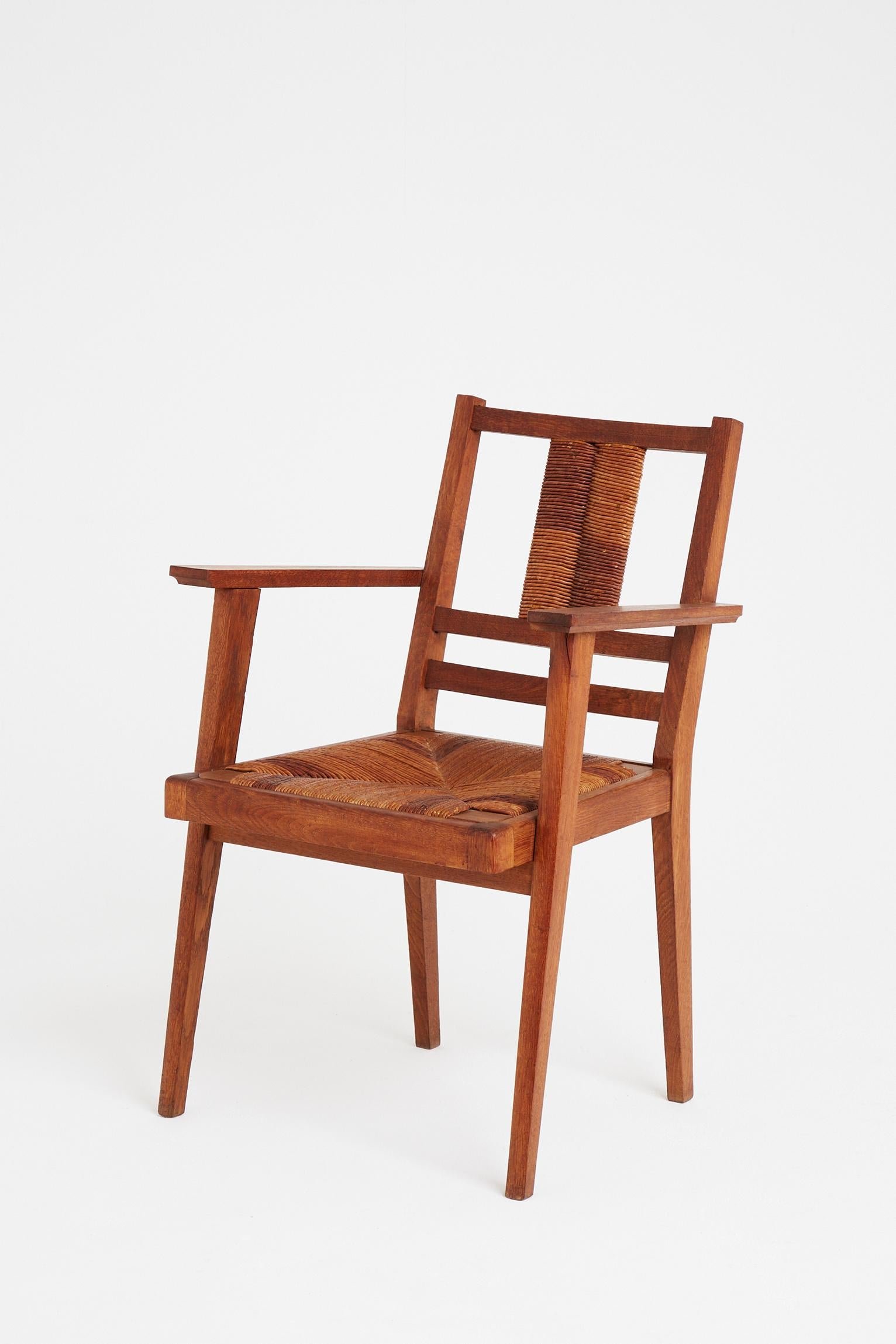A stained oak and rush armchair, possibly by Francis Jourdain (1876-1958).
France, circa 1940.