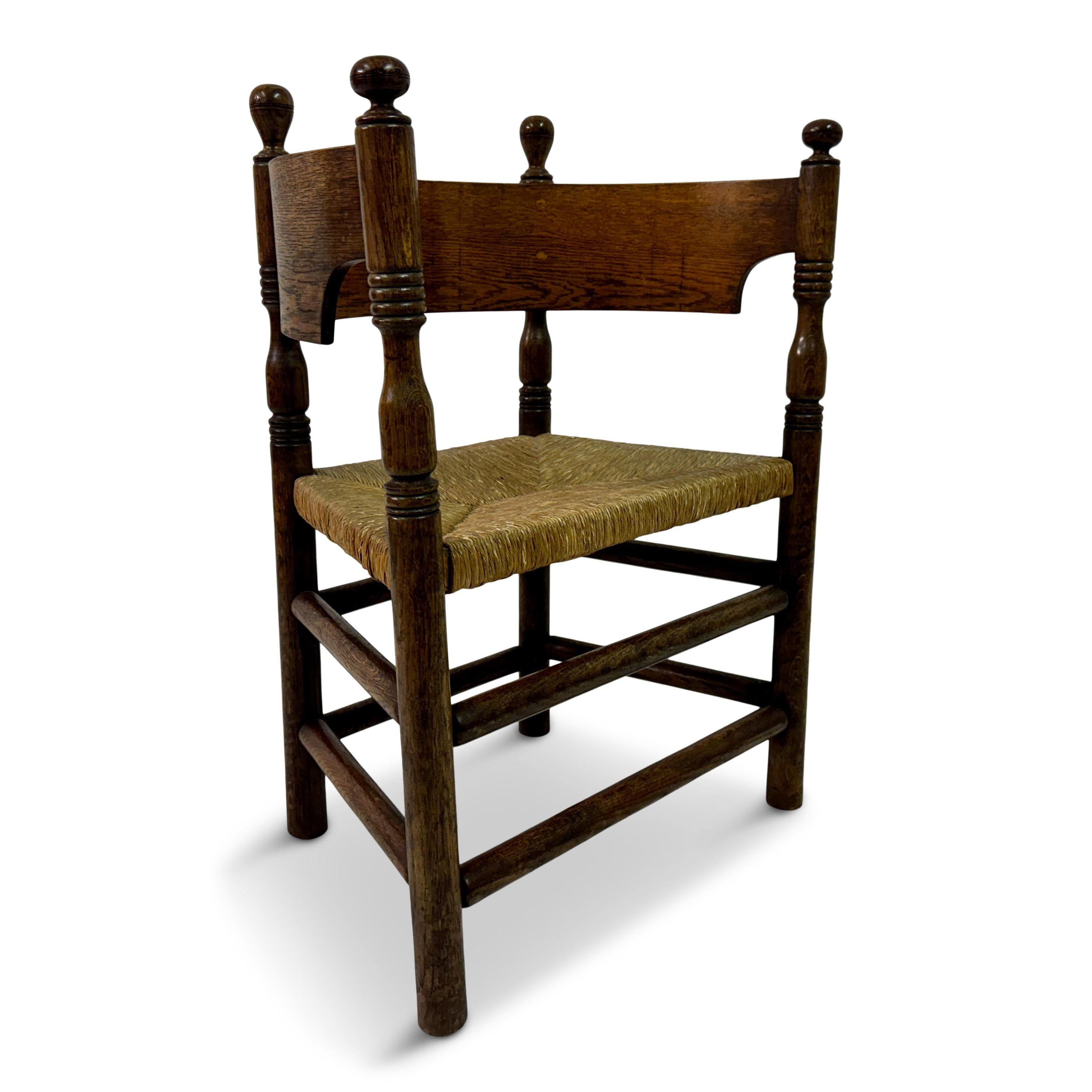Sillón de media caña de principios a mediados del siglo XX con asiento de junco

Se trata de una silla de madera de estilo Arts and Crafts de principios del siglo XX con respaldo en forma de media luna. Fabricada en roble, tiene unas características