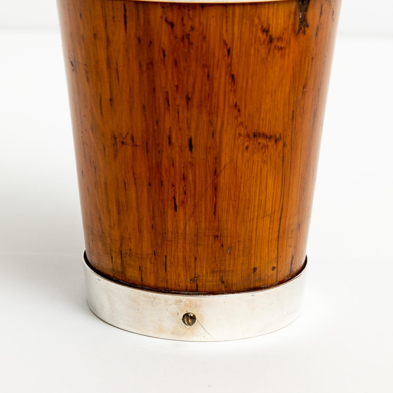 Circa 1930s carved oak and silver plate beaker in the Classic English style. Made in England and stamped with maker's hallmarks on the base. The silver plate accents the oakwood as bands wrapping around the exterior of the beaker and on the top rim.