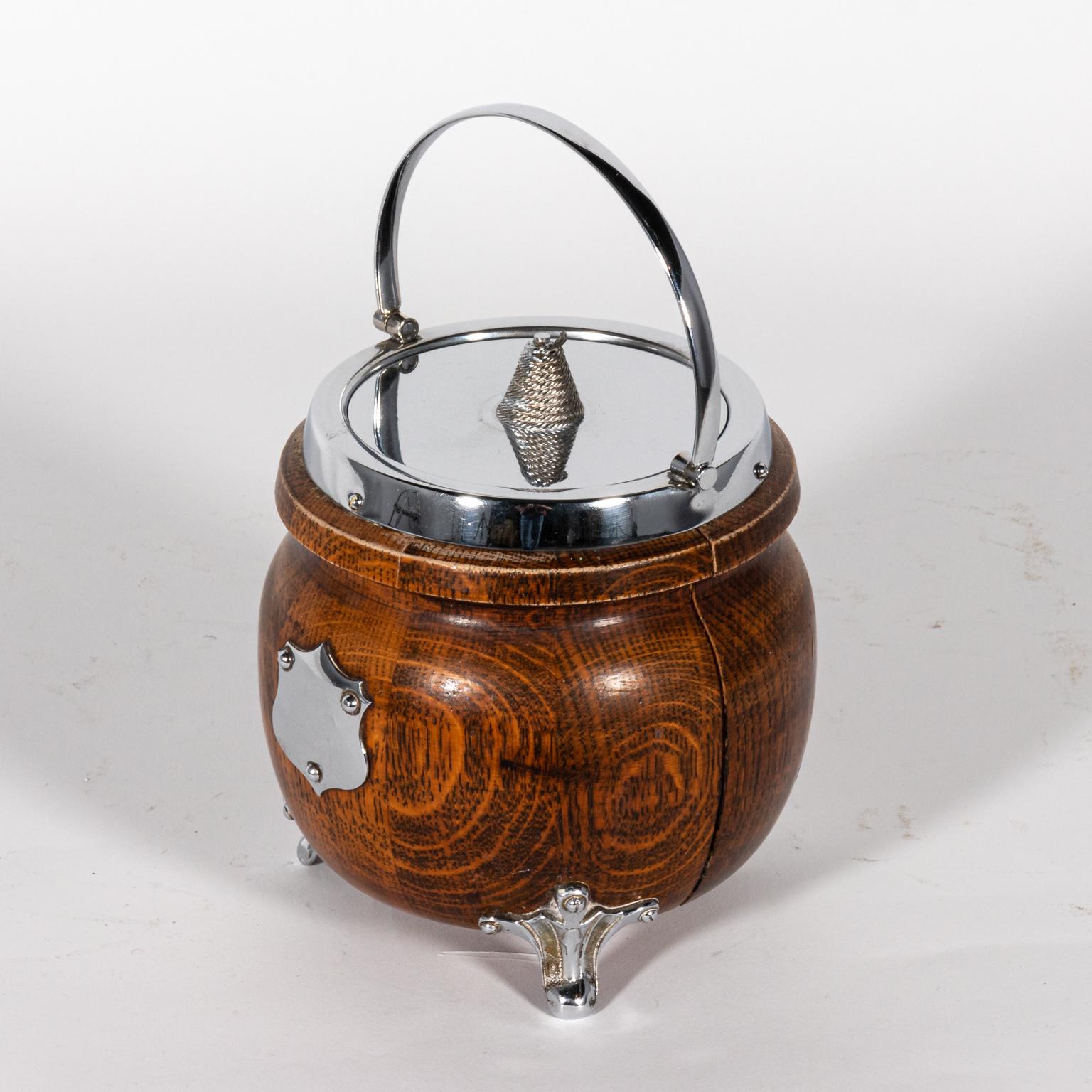 Oak and silver ice bucket with handle and lid. The piece also features a shield motif on the front. Please note of wear consistent with age including minor surface scratches.