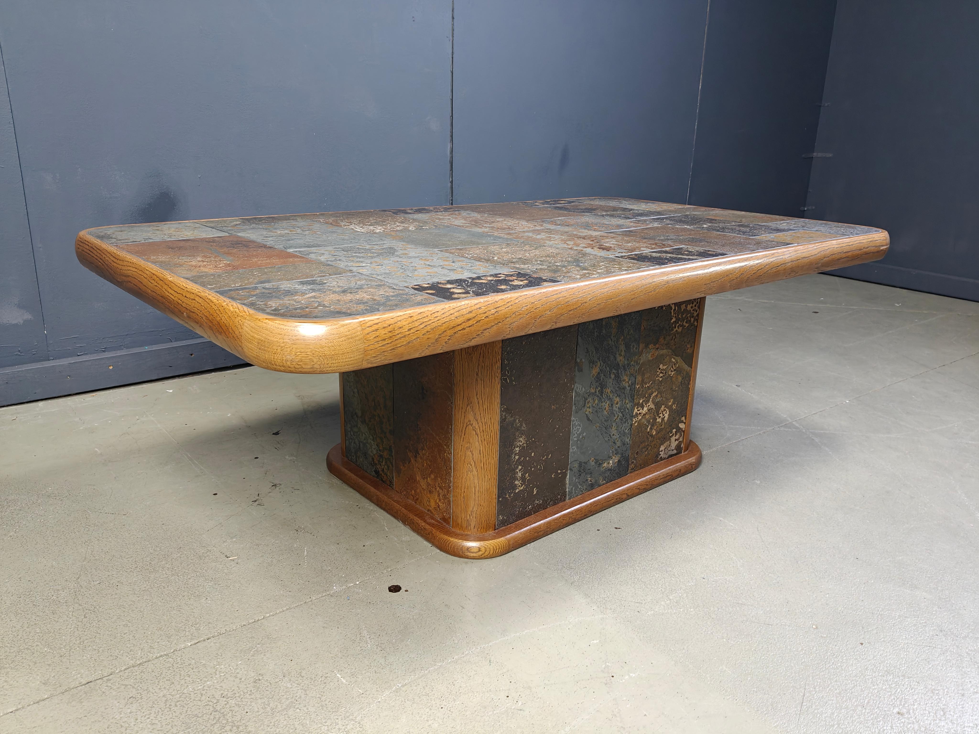 Vintage brutalist coffee table in the manner of Paul Kingma. 

This brutalist coffee table has an oak frame with inlaid slate and lava stones to create a beautiful effect.

Good condition

1970s - Germany

Height: 52cm
Width: 144cm
Depth: