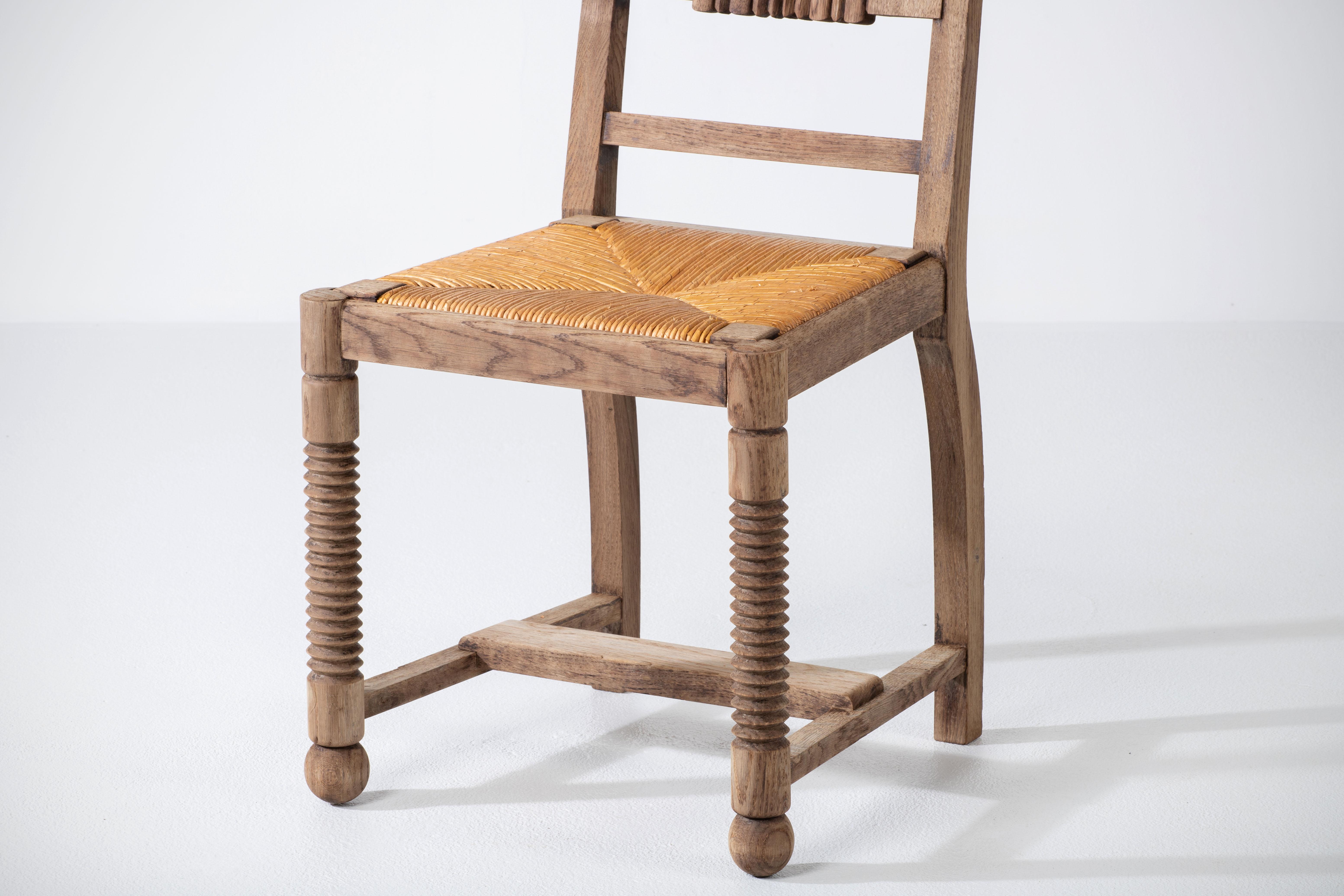 This French Art Deco dining chair in solid oak was created in the 1940s by Charles Dudouyt.

We can clearly see the work of the French school of the 1940s. The detailed and graphic designed backrest panels will meet the standards of the most