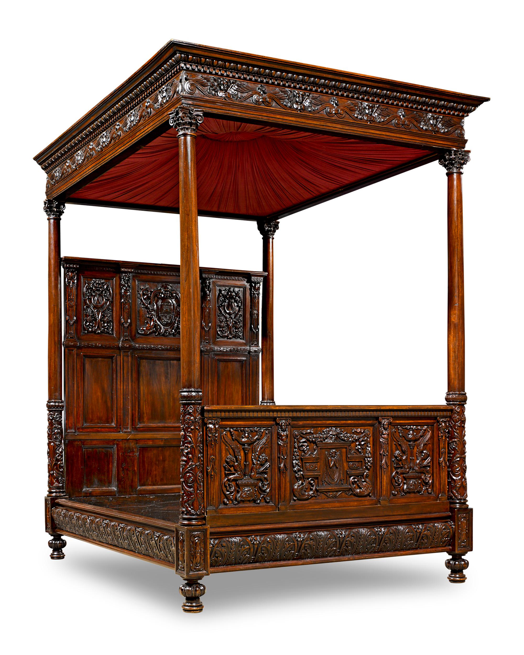 This lavish American oak and walnut tester bed exhibits superior craftsmanship and detail. The design is embellished by elaborate carving throughout in a neoclassical motif the includes shields, crowns, acanthus leaves, laurel wreaths, stylized