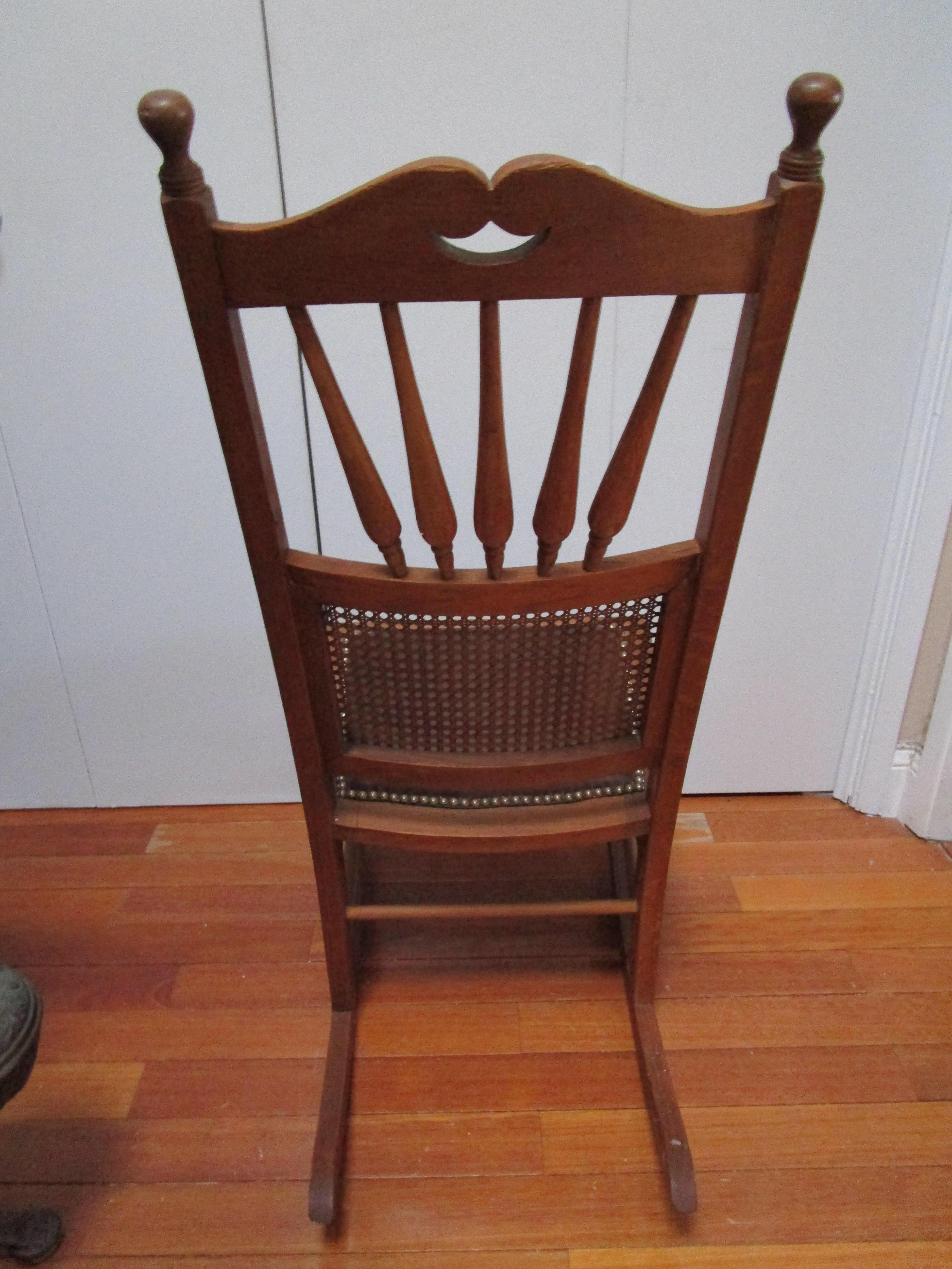 The main feature of this piece is the condition. The wood patina and overall condition of the rocker is  quite attractive: beautiful oak and restored seat in rich brown leather.  This estate sale find is an antique Victorian style. The chair has