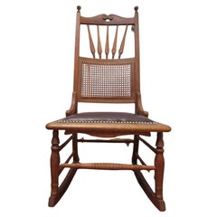 Chaise à bascule ancienne en chêne avec assise en cuir et dossier en rotin Clavos