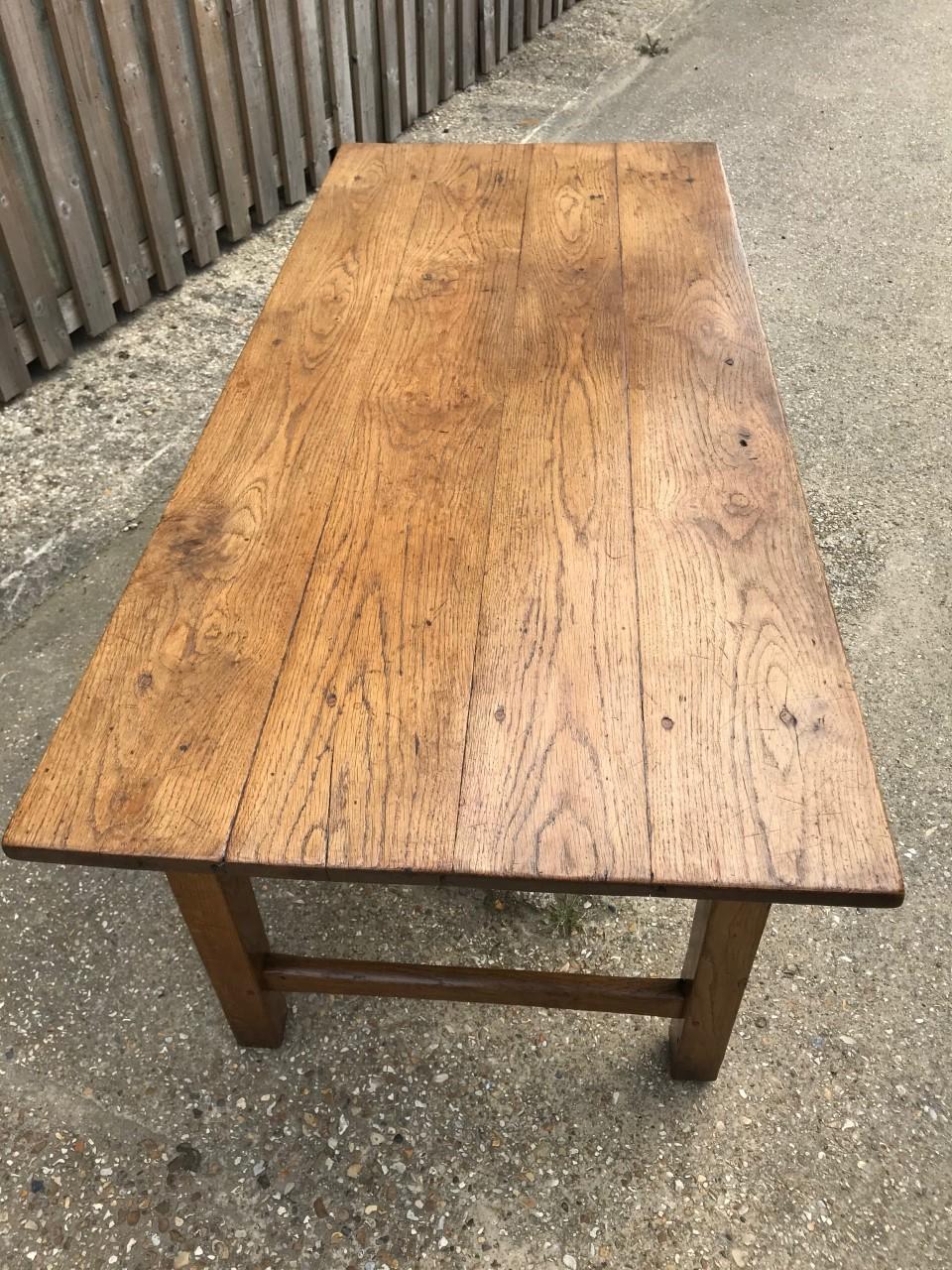 Two-drawer antique oak desk with four plank top. The end stretcher supports square legs. Gorgeous color and patination. Lovely as a little desk or lamp table. Could also be used as small dining table.