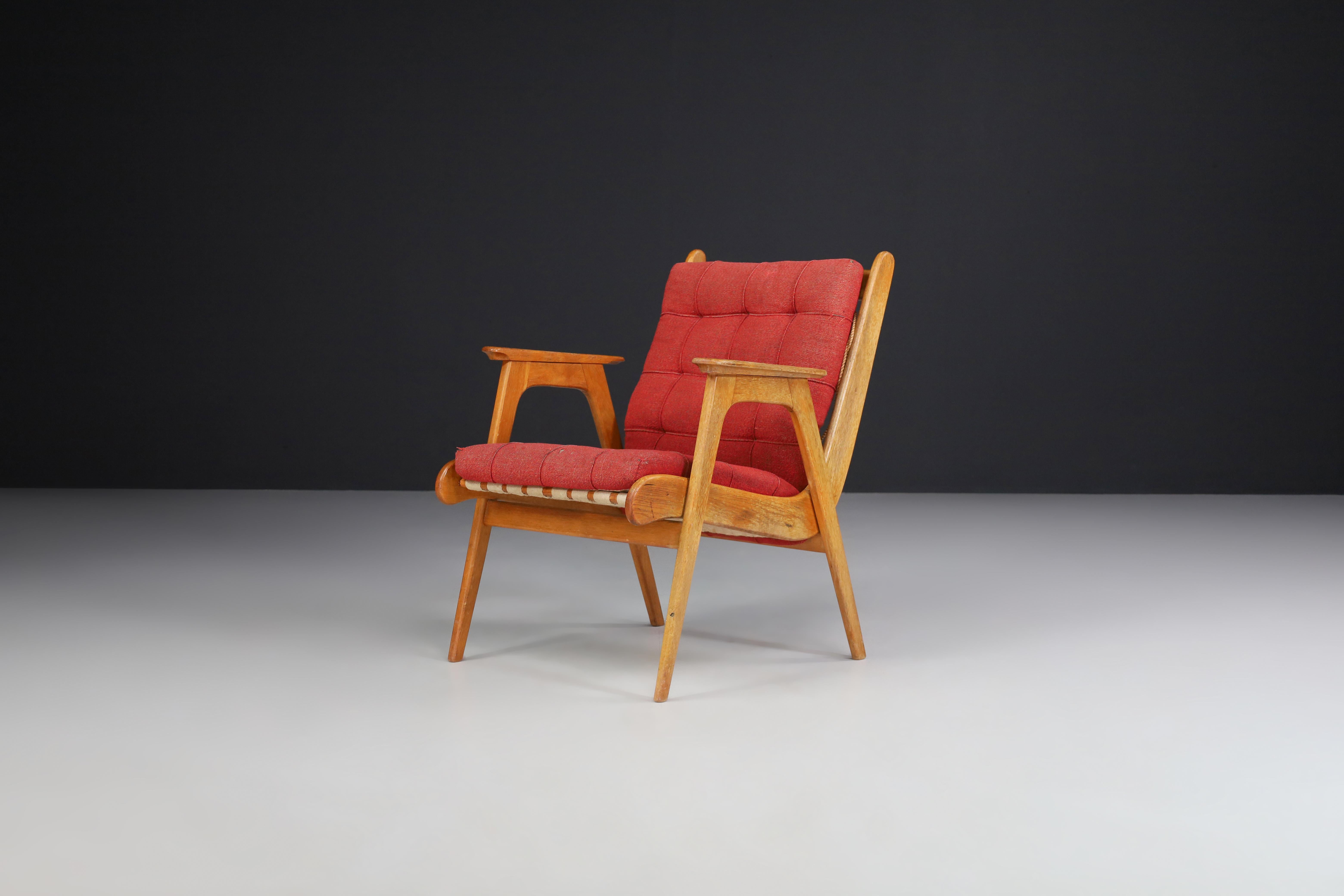 Oak armchair with red upholstery, France 1950s

Midcentury oak armchair manufactured and designed in France 1950s. This armchair has the original upholstery fabric and a lovely elegant french oak frame. It is in perfect condition, minor patina on
