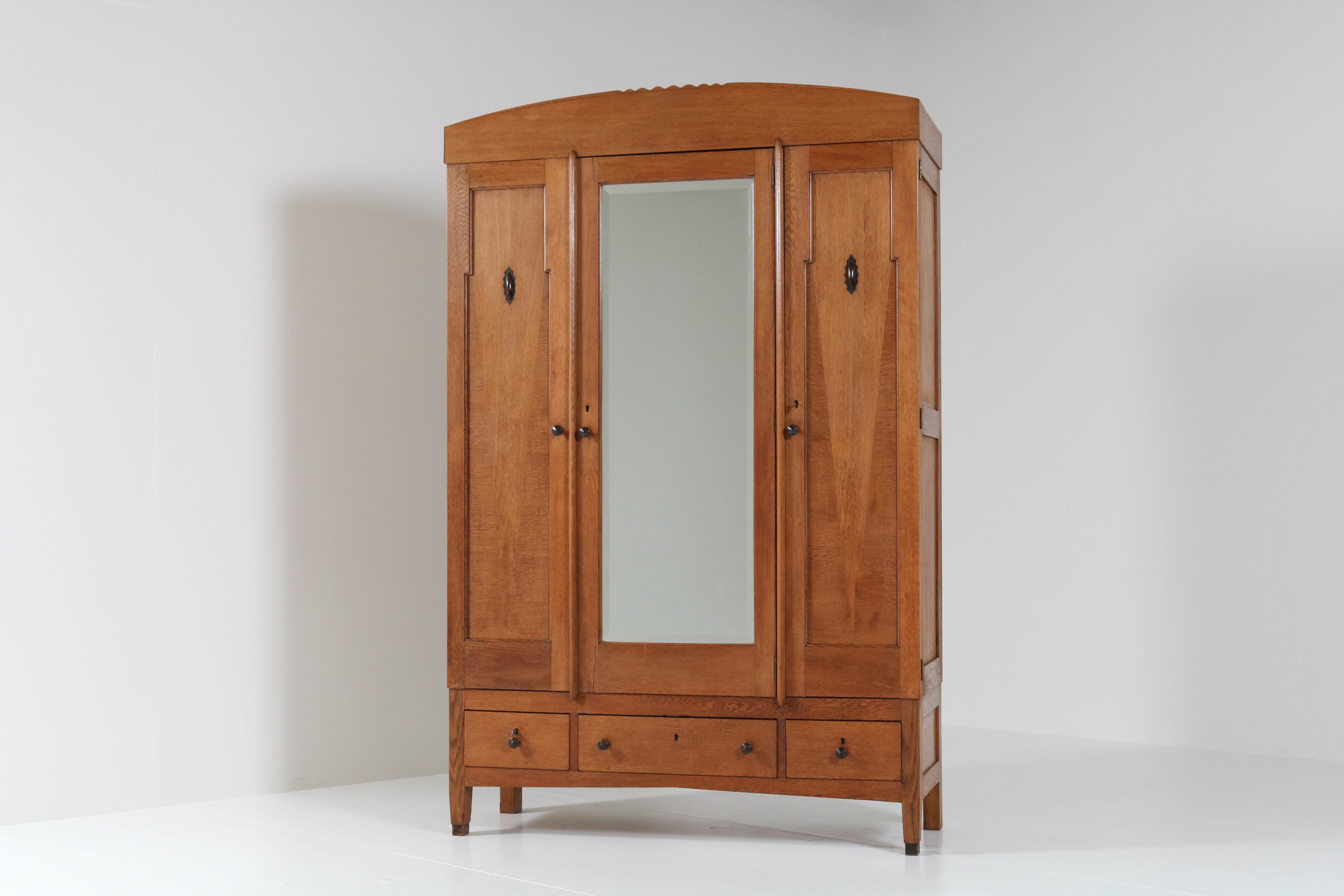 Wonderful and rare Art Deco Amsterdam School armoir or wardrobe.
Striking Dutch design from the twenties.
Solid oak with solid Macassar ebony knobs on doors and drawers.
This armoir with the original bevelled mirror can be dismantled for easy