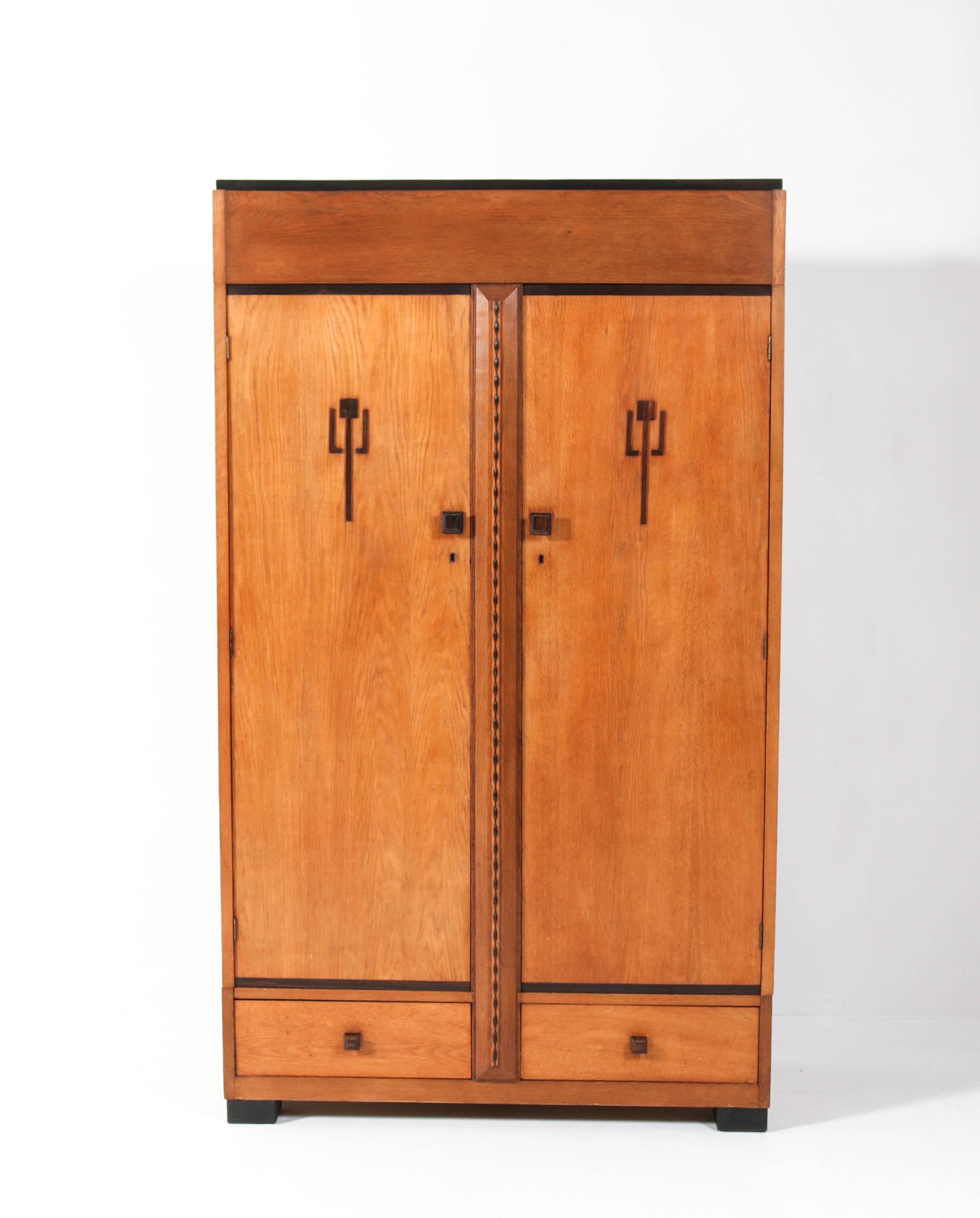 Stunning and rare Art Deco Amsterdam School armoire or wardrobe.
Striking Dutch design from the 1920s.
Solid oak and oak veneer with solid Macassar ebony handles.
Four solid oak shelves adjustable in height.
This wonderful piece of furniture can