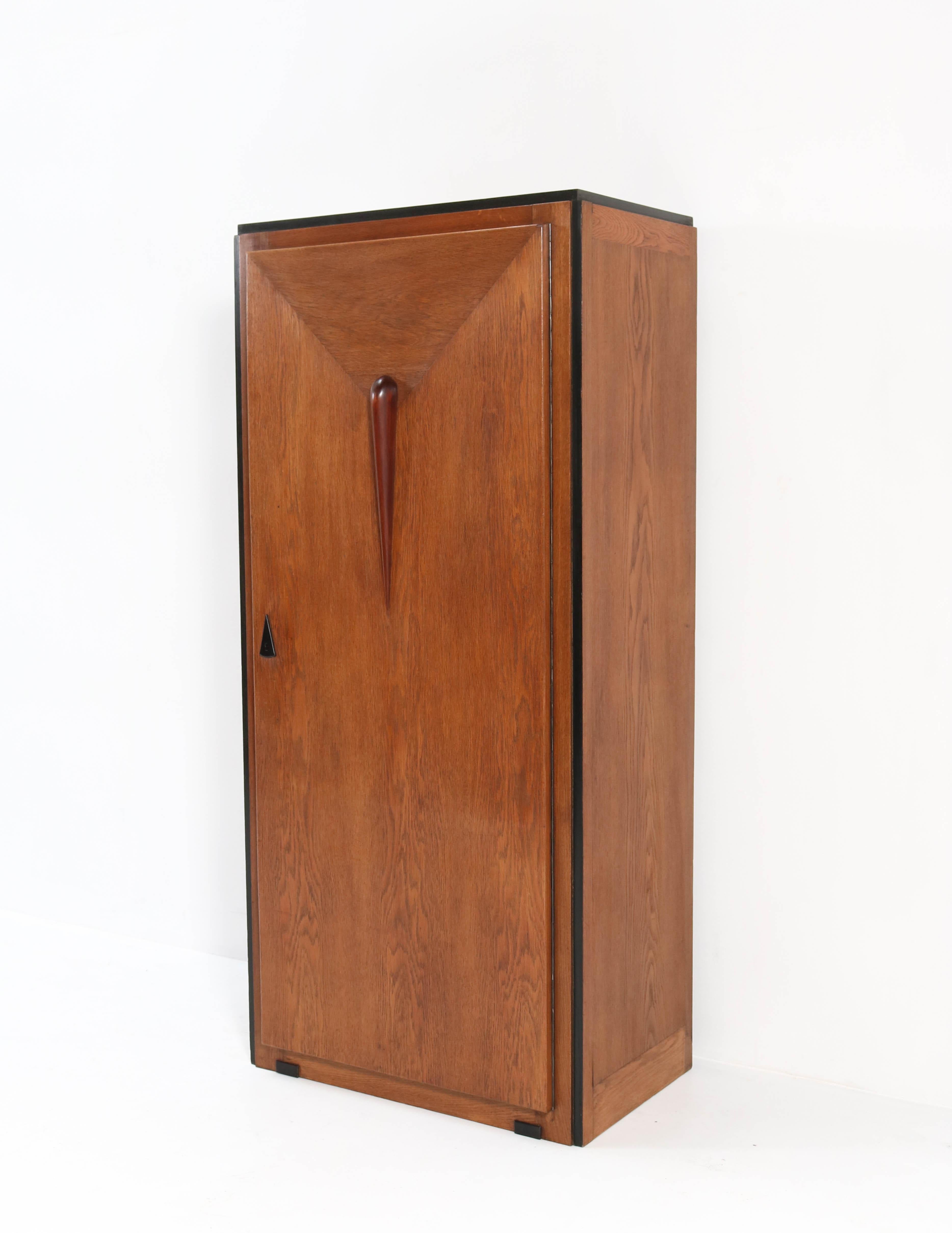 Magnificent and rare Art Deco Amsterdam School armoire or wardrobe.
Striking Dutch design from the 1920s.
Oak and oak veneer with padouk and original black lacquered lining.
This wonderful piece of furniture can be used as a room divider because the