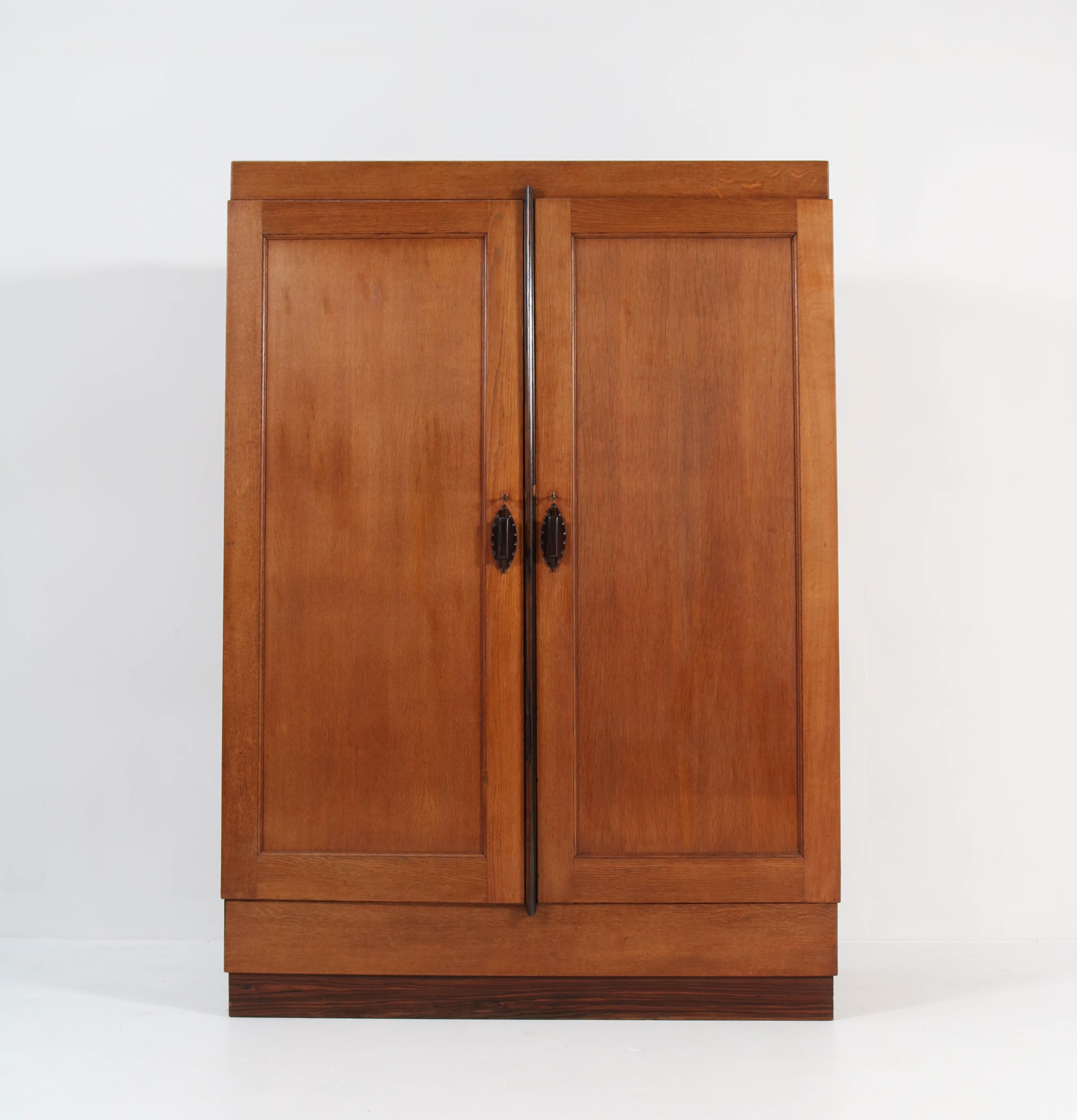 Stunning and rare Art Deco Amsterdam School armoire or wardrobe.
Design by H.W. Tolenaar Rotterdam.
Striking Dutch design from the 1920s.
Oak with original solid Macassar ebony handles and lining.
Four original solid oak shelves adjustable in