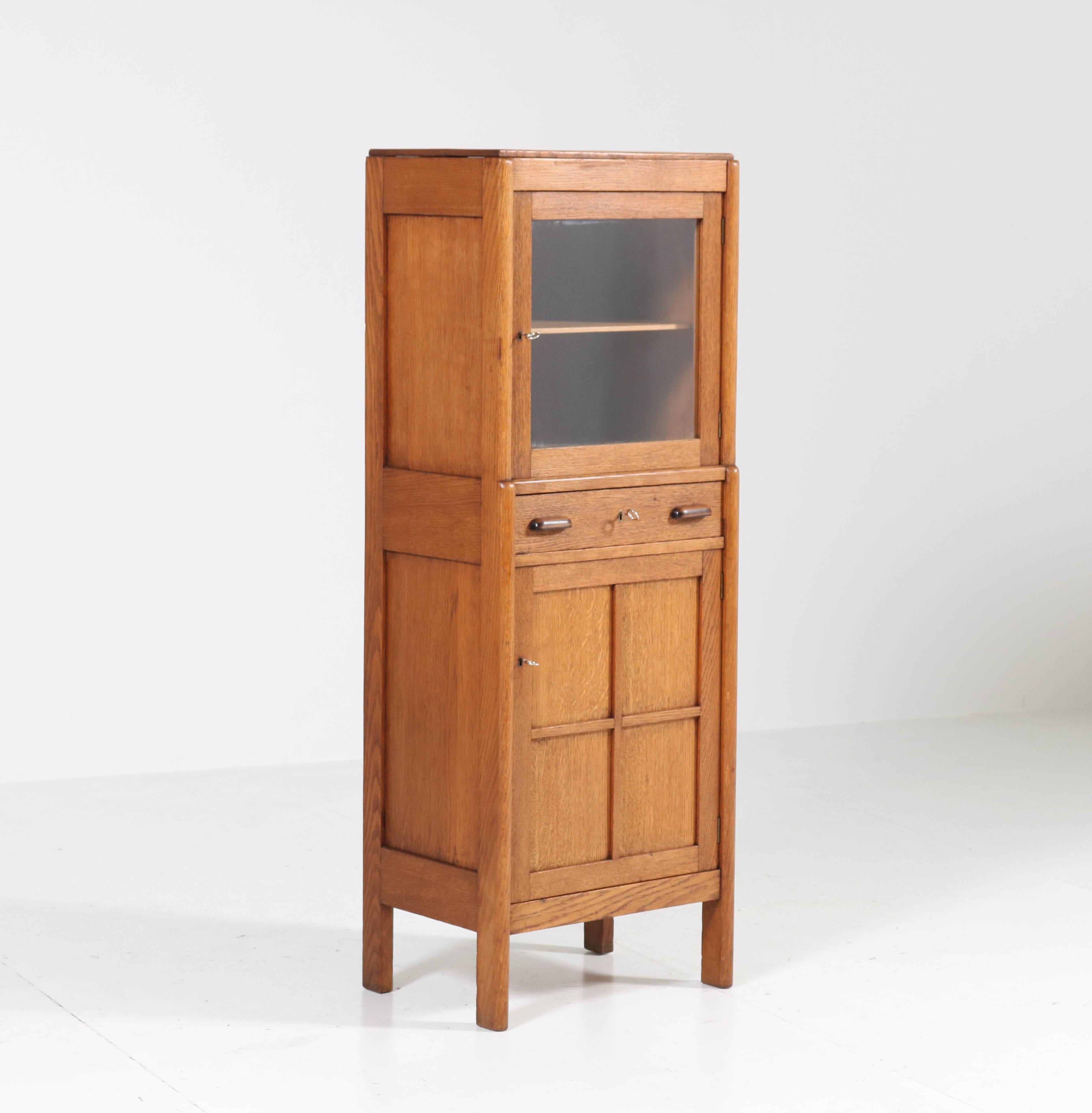 Wonderful and rare Art Deco Amsterdam School cabinet.
Striking Dutch design from the twenties.
Solid oak with solid ebony Macassar knobs on the drawer.
Three locks and keys in good working order.
In good original condition with minor wear